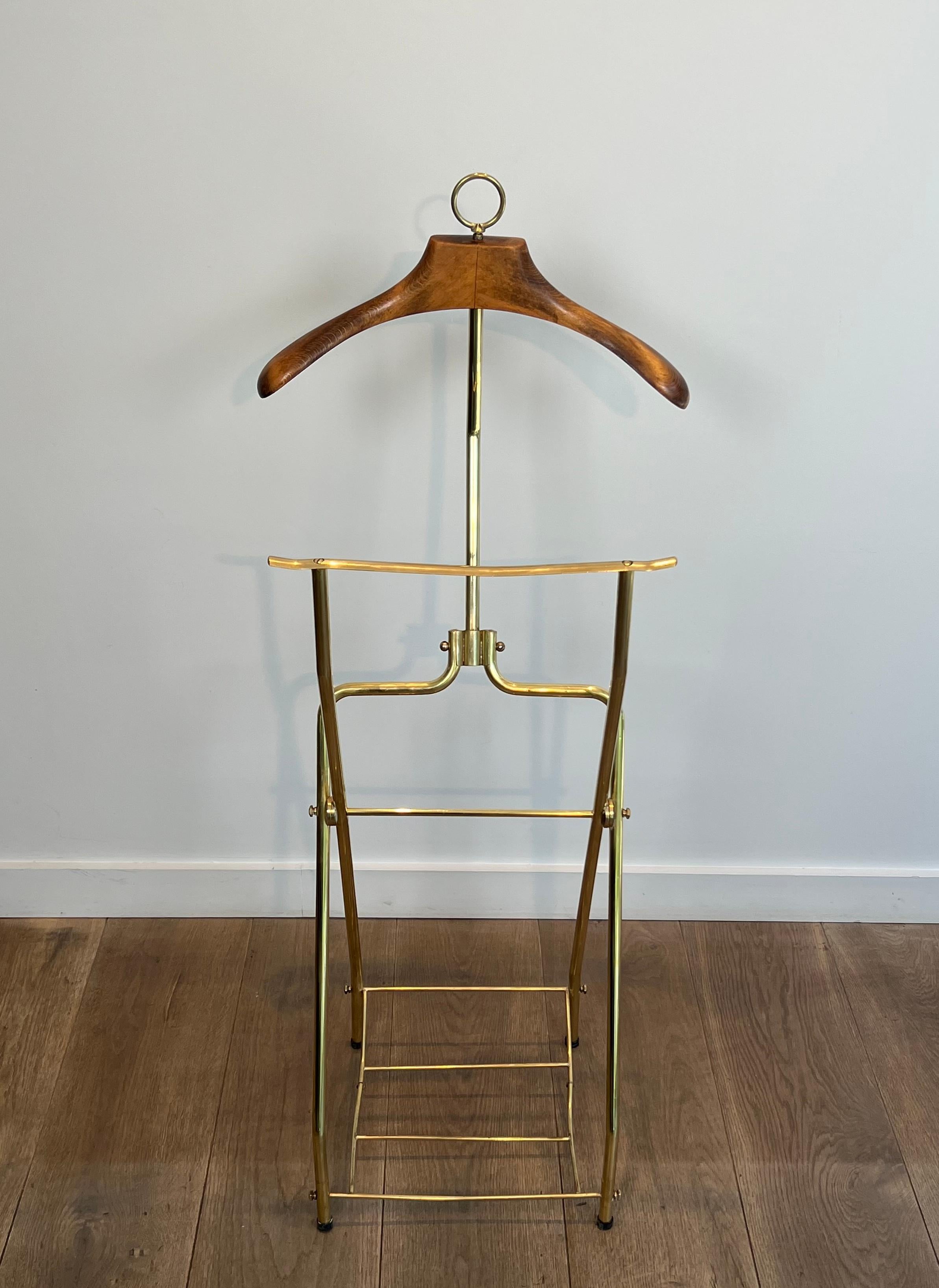 Questo simpatico valletto pieghevole in stile neoclassico è realizzato in ottone e legno con base tripode su rotelle. Questa è un'opera francese. Circa 1940