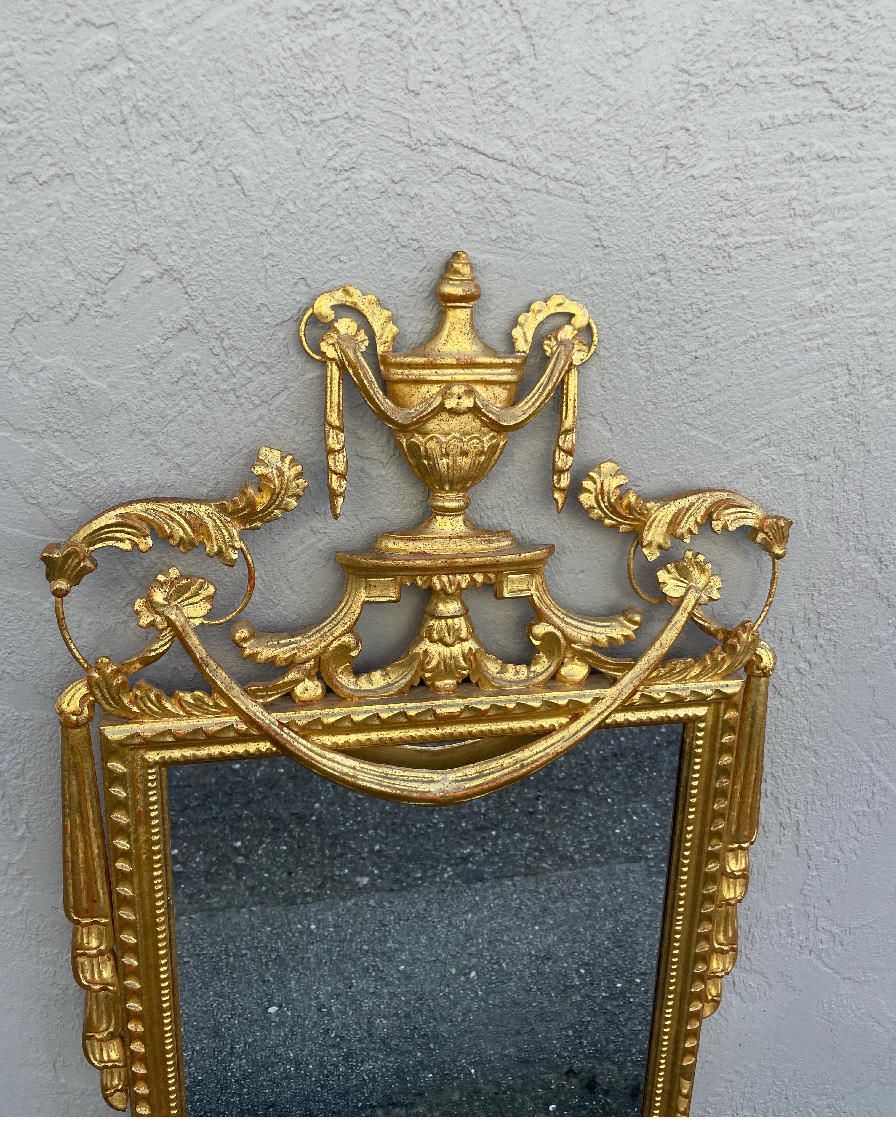 Neoclassical giltwood Italian wall mirror by Le Barge. Beautifully detailed with a large Urn at top and swags adorning each side.