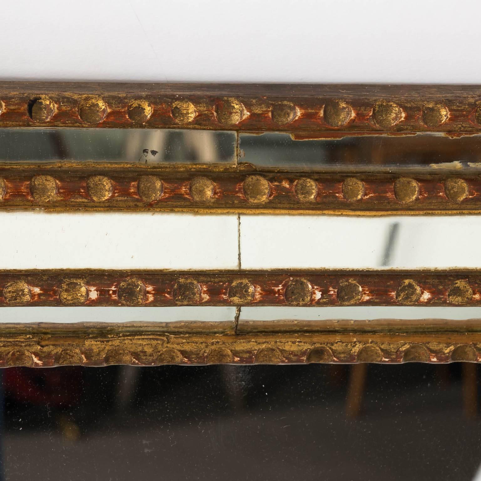 A large gilt mirror with mirrored insets.
 