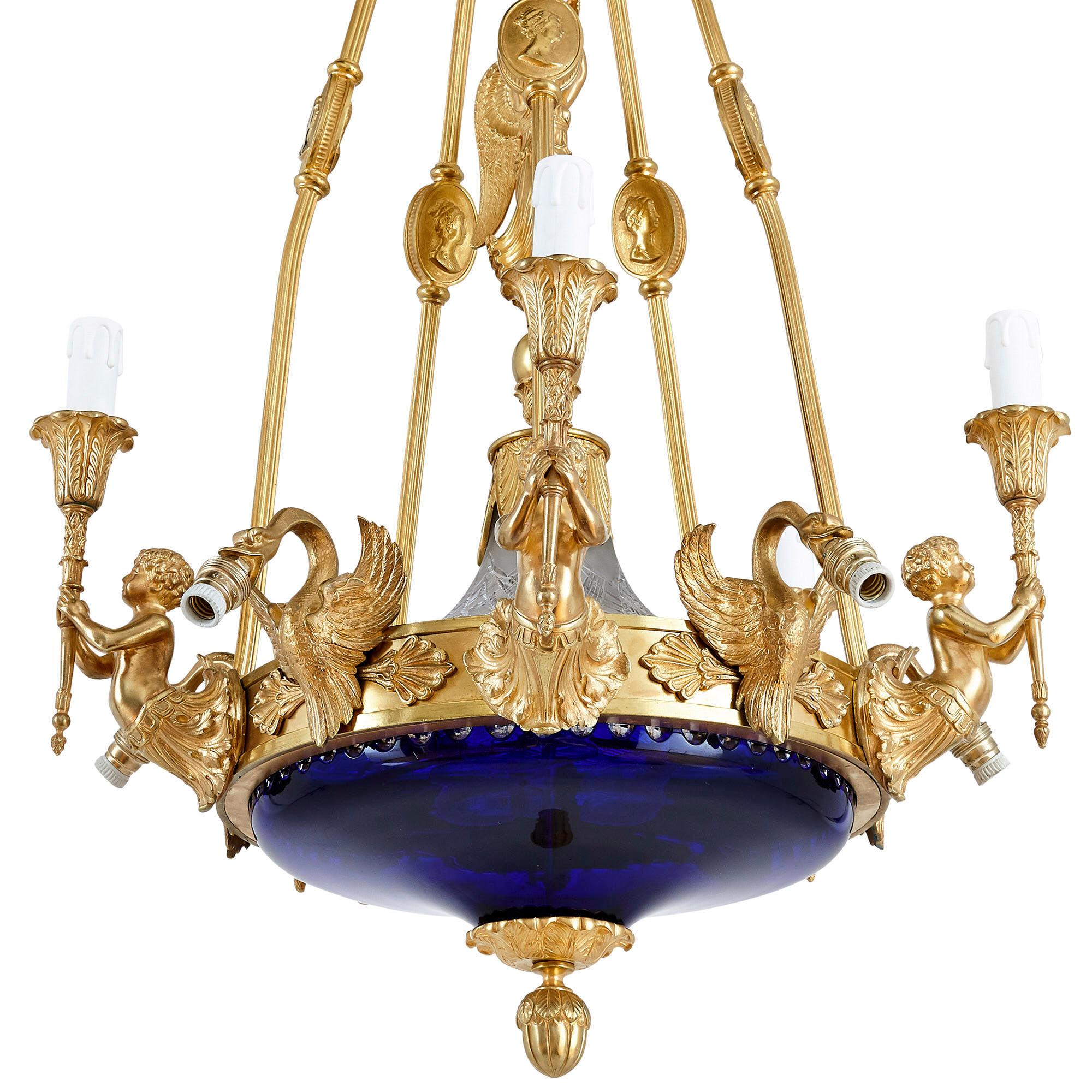 Neoclassical style gilt bronze and cobalt blue glass chandelier
French, early 20th century
Measures: Height 97cm, diameter 56cm

This beautiful neoclassical style chandelier is reminiscent of both the Louis XVI and Empire decorative styles: the