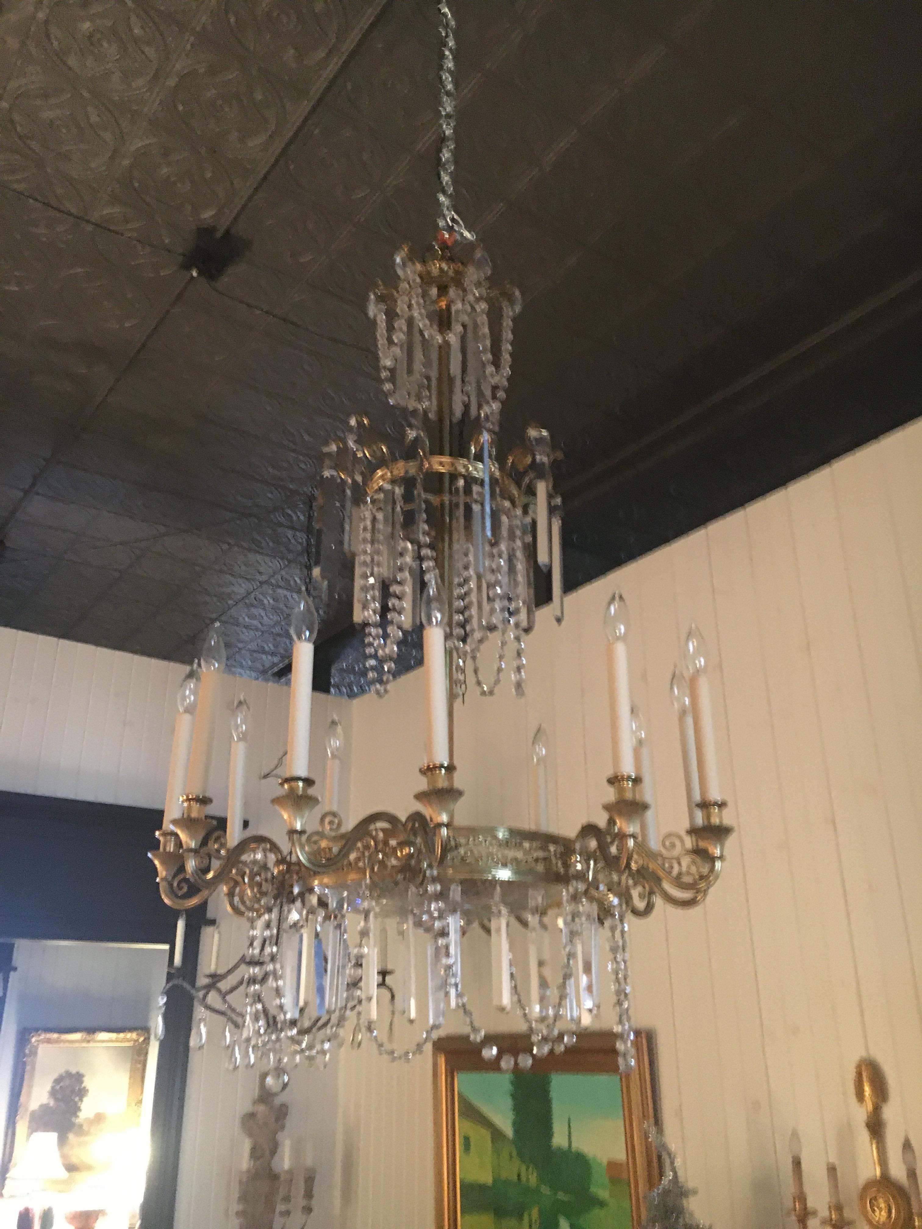 Lampadario a dodici luci in bronzo dorato in stile neoclassico. Misure: altezza 41 x diametro 29 pollici. Bellissima vista dal basso.  Non esitare a chiamare o inviare un'e-mail per ulteriori domande.