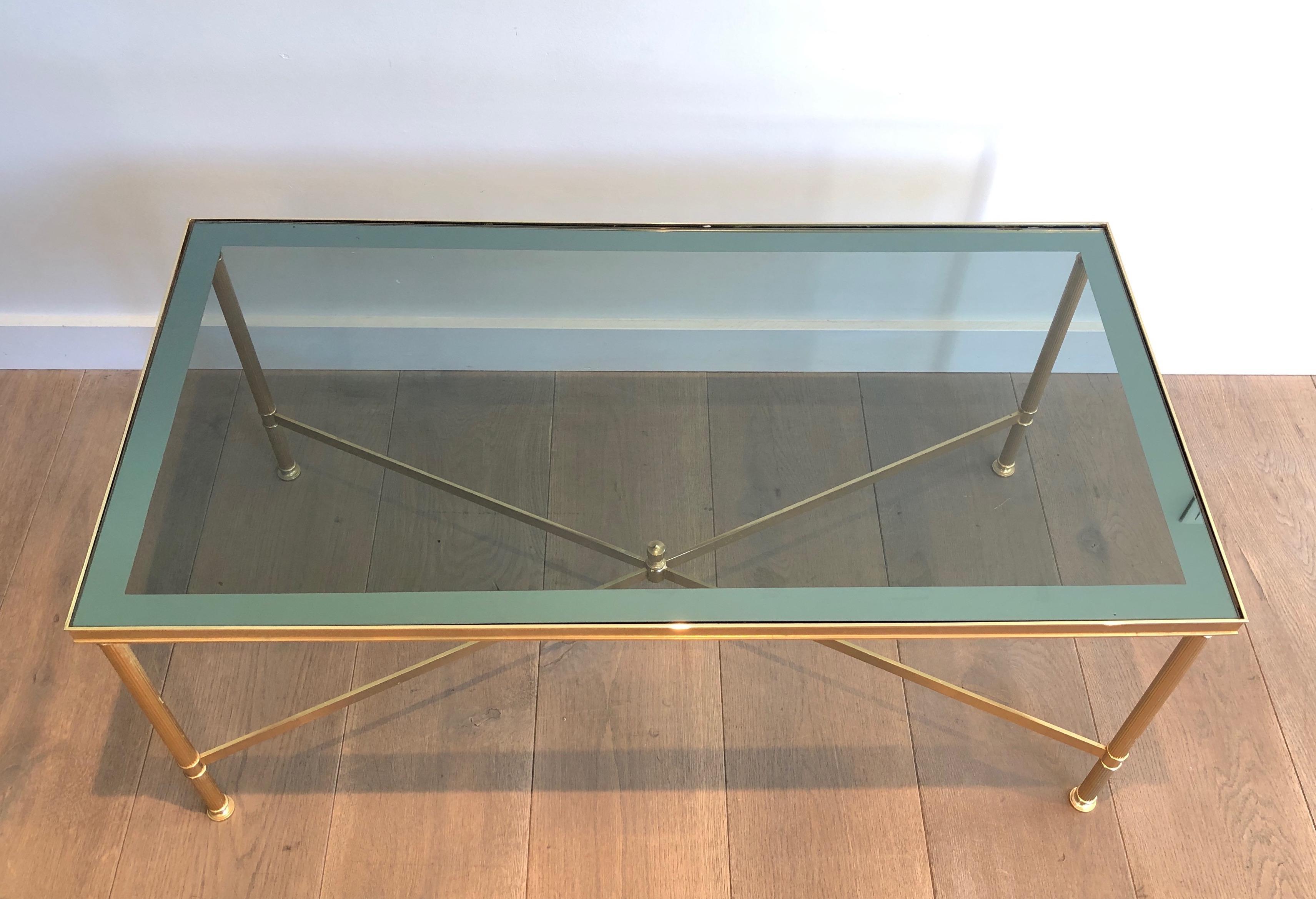 This nice neoclassical style coffee table is made of gilt metal with blueish glass shelf. This is a French work in the style of Maison Jansen. Circa 1940