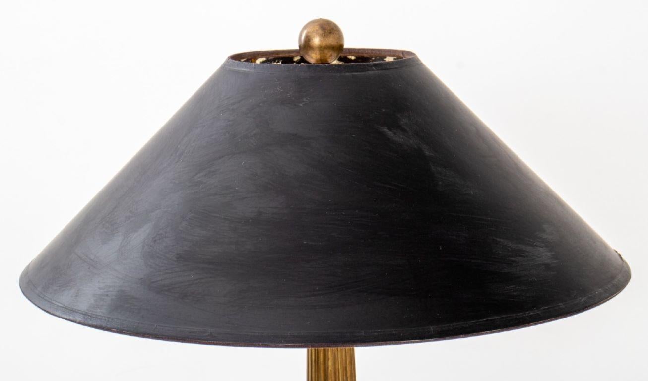 Neoklassizistische Tischlampe aus vergoldetem Metall in der Art von Karl Springer (geb. 1931), mit schwarzem Schirm, offenbar unsigniert.