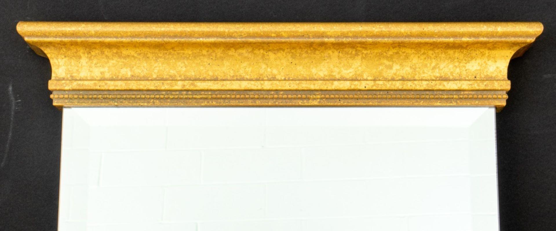 Miroir biseauté de style néoclassique avec moulure en bois doré sculpté en haut et en bas. Mesures : 34