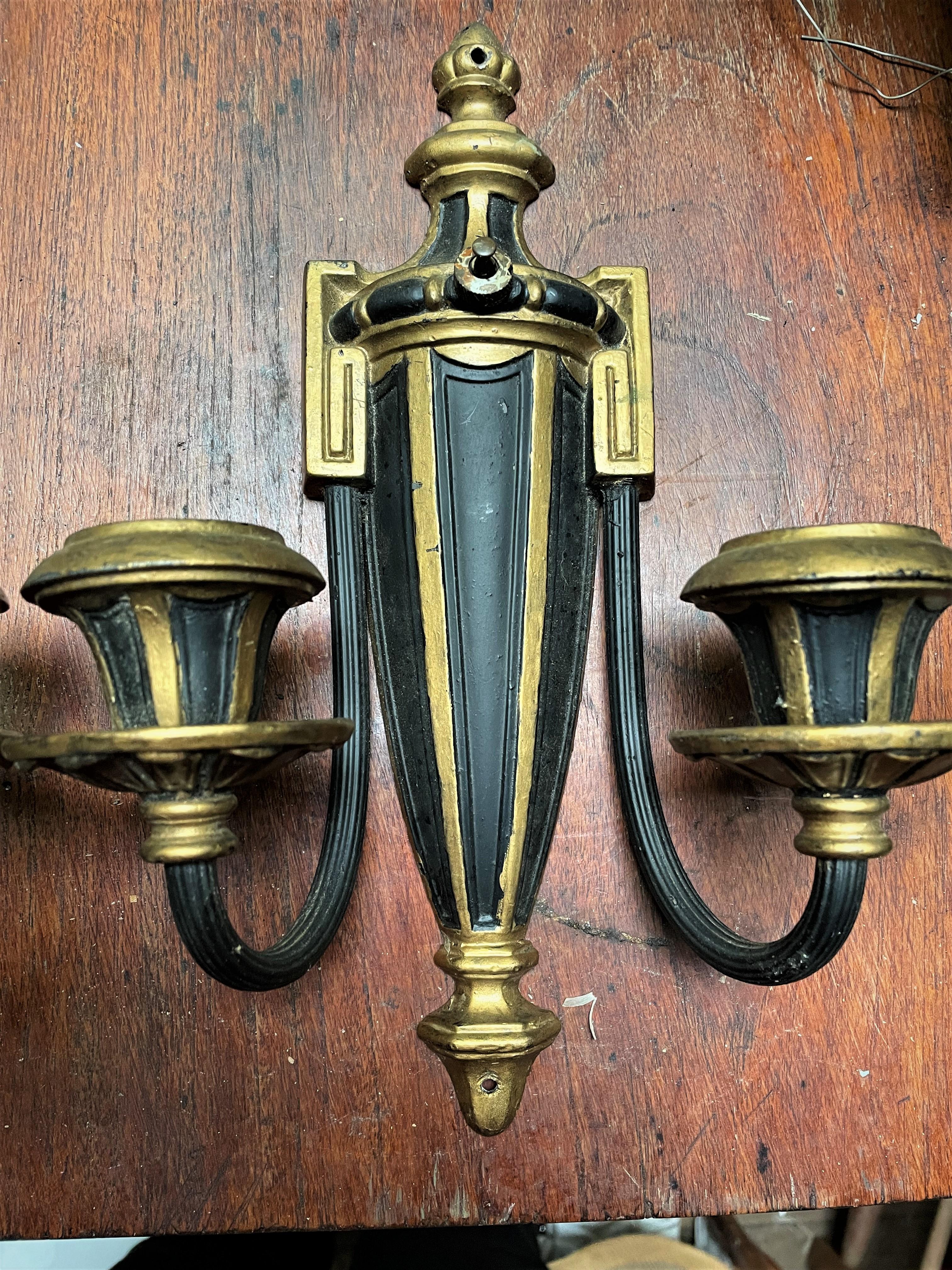 This is a great looking pair of neoclassical style sconces with a streamlined urn shape in the center and Greek Key designs where the arms meet the urn. The sconces were once electrified, but are not now They can certainly be wired again and still