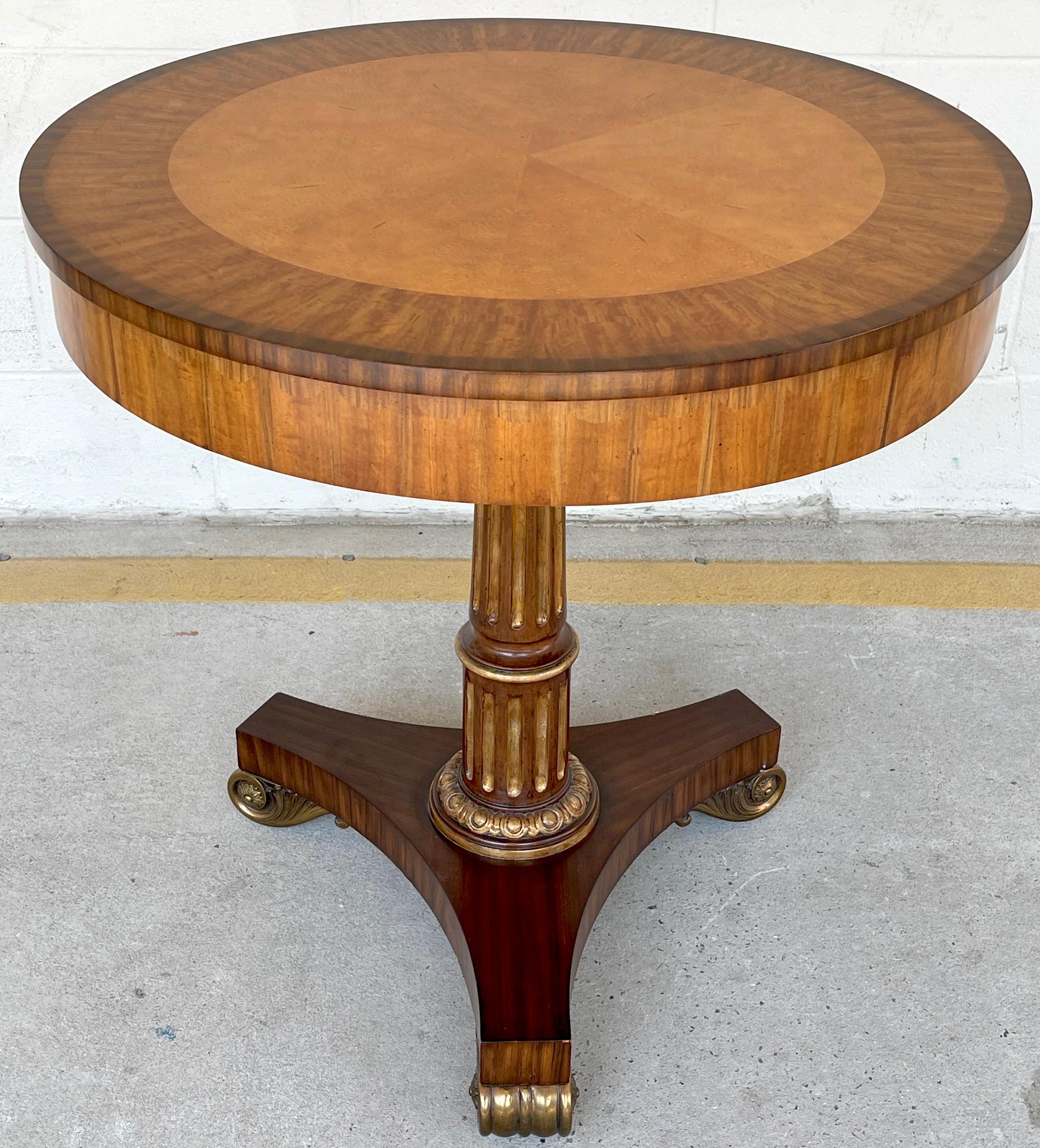 Neoclassical style inlaid side table with bronze feet, by Maitland-Smith, Of circular form with Fine inlays of burl and satinwood, raised on a reeded mahogany parcel gilt column on a bronze footed triparte base.