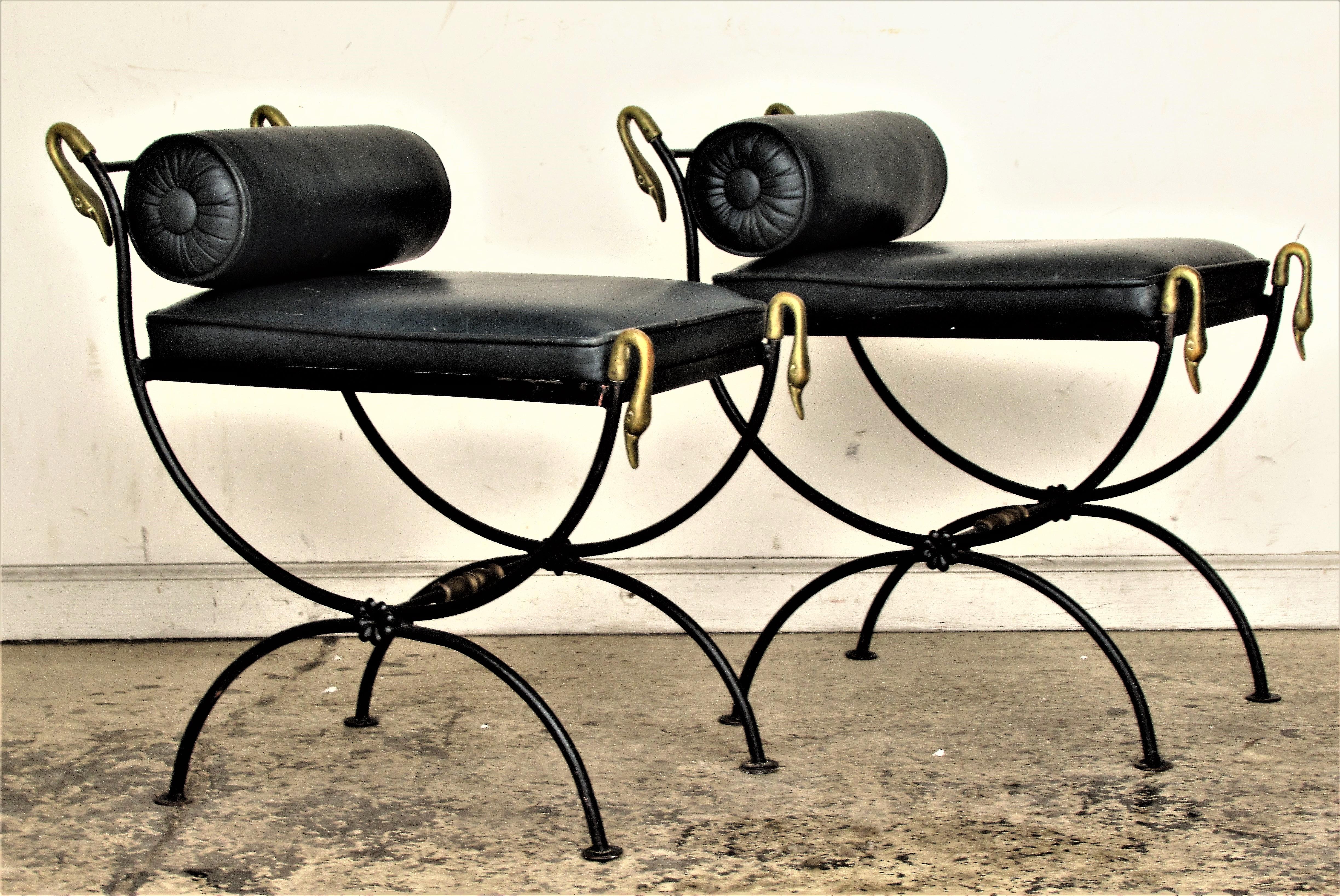 A matched pair of black painted iron neoclassical style curule form benches with brass swan heads / brass elements. Both benches in beautifully aged old surface with nicely upholstered black leather seats and removable bolster cushions. In the style