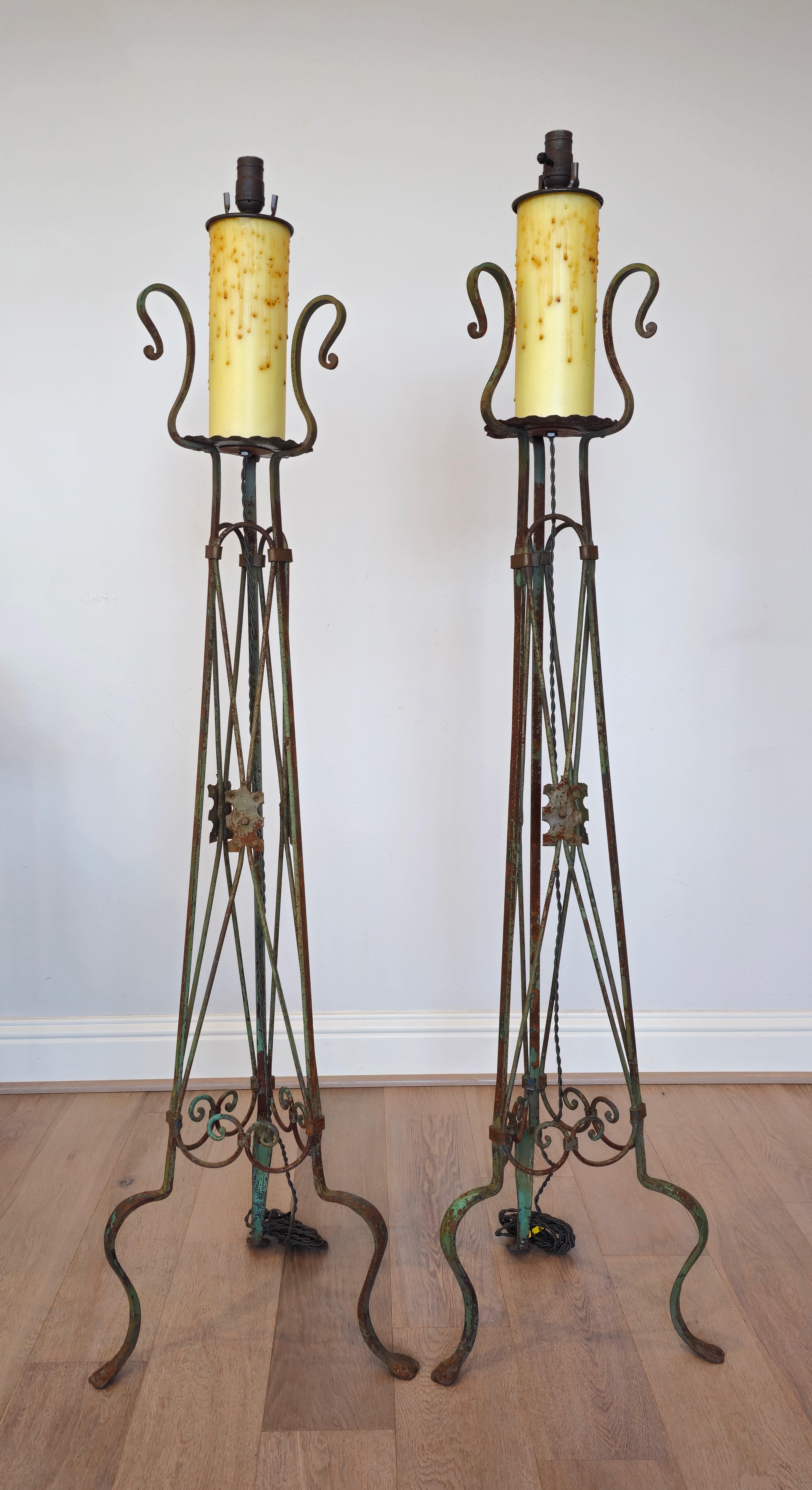 A magnificent pair of antique Athenian Neoclassical style scrolled iron faux candlestick torchères - floor standing lamps.

Each with single light mounted over large oversized faux candle, rising on heavily patinated distressed painted green iron