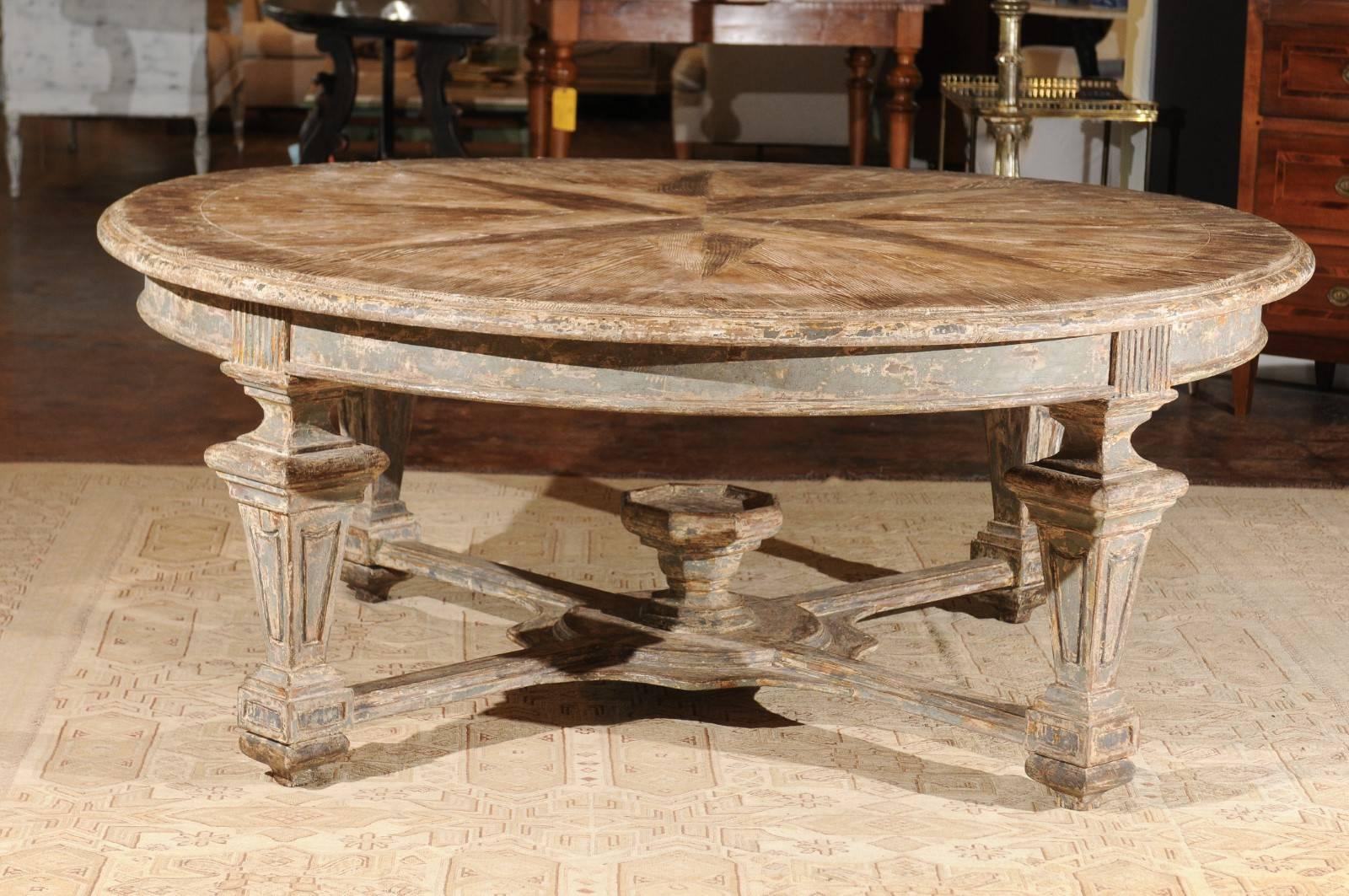 An Italian neoclassical style handmade wooden round dining table with star-inlaid top, column legs and cross stretcher. Handmade in Italy, this exquisite dining table features a circular top, beautifully inlaid with an oversized star motif, with
