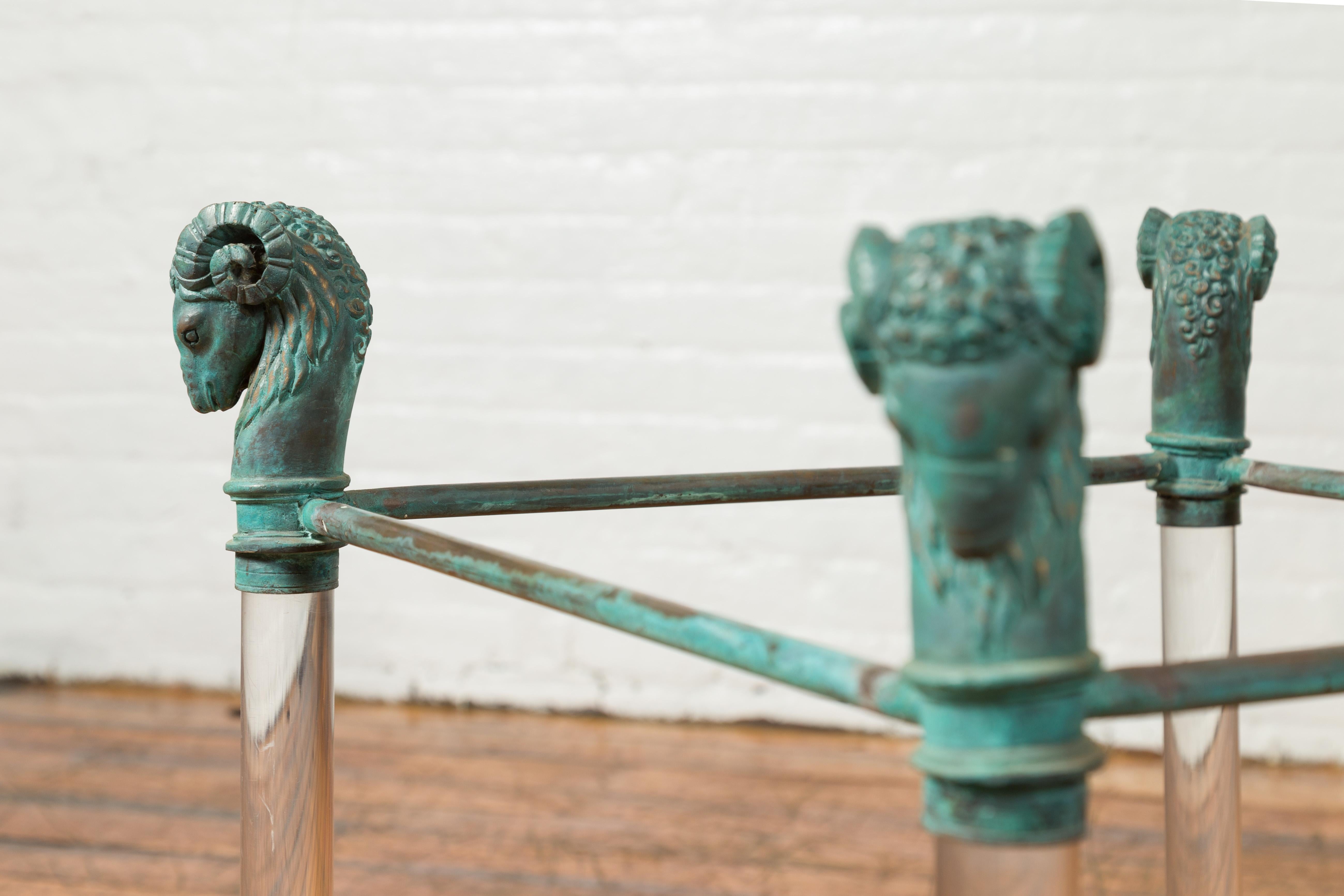 Ein zeitgenössischer Lucite-Couchtischsockel im neoklassischen Stil aus dem 21. Jahrhundert mit Widderköpfen aus grüner Bronze. Dieser zeitgenössische Lucite-Couchtischsockel im neoklassischen Stil aus dem 21. Jahrhundert verbindet auf elegante