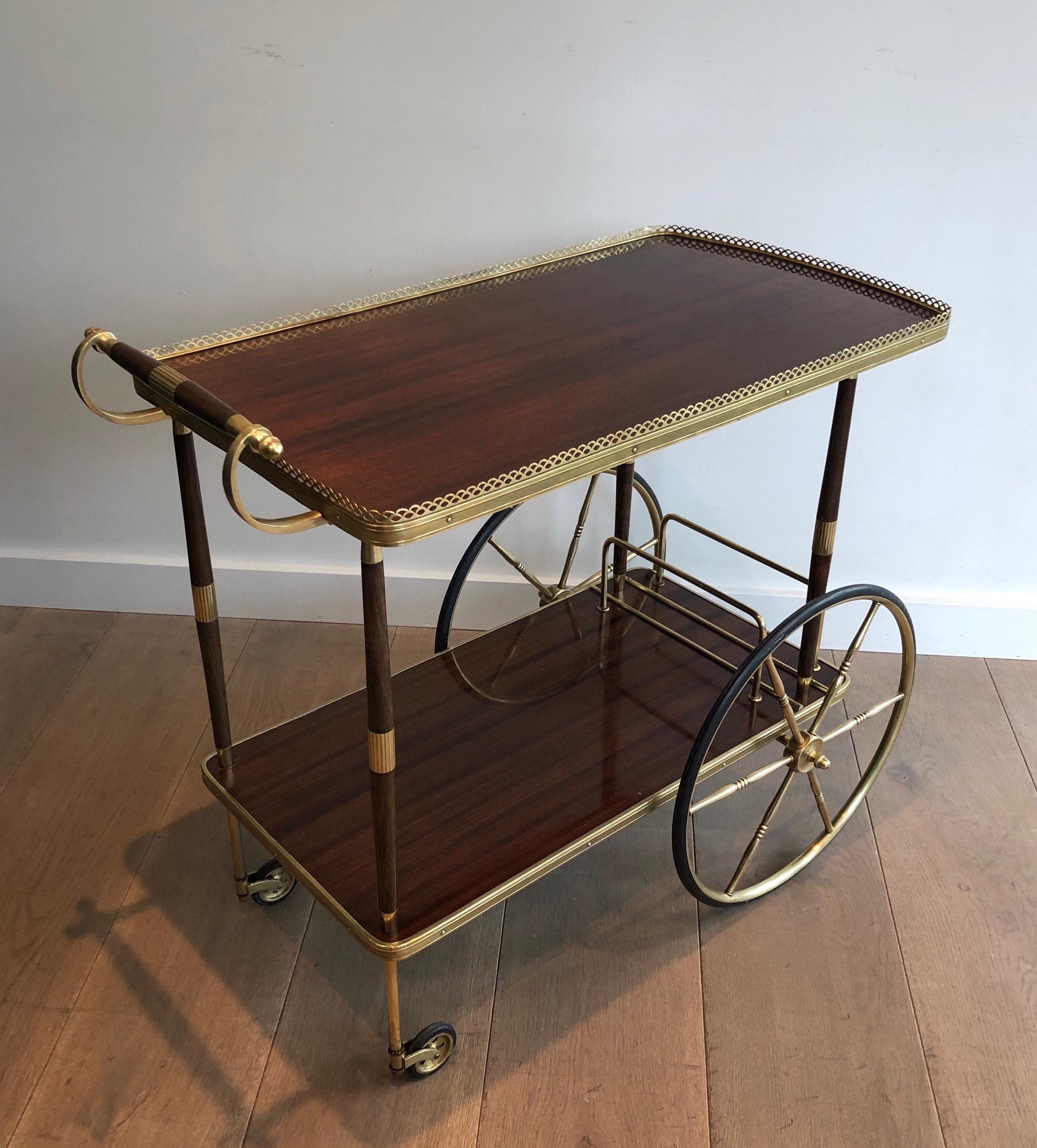 This elegant neoclassical style bar cart is made of wood and brass. This is a French work in the style of famous designer Maison Jansen. Circa 1940.