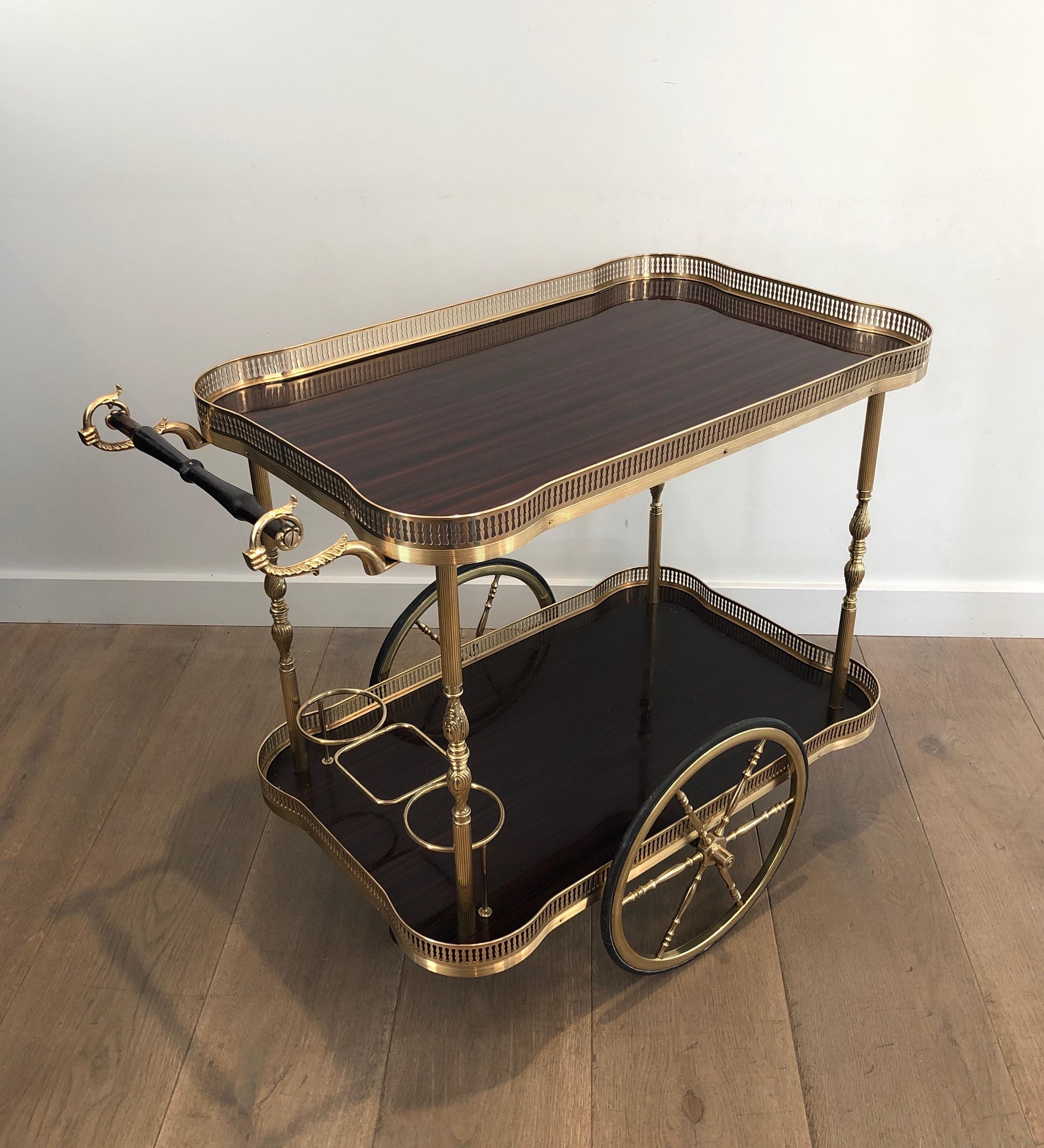 This neoclassical style bar cart is made of brass and mahogany. This is a French work, in the style of famous Maison Jansen, circa 1940.
