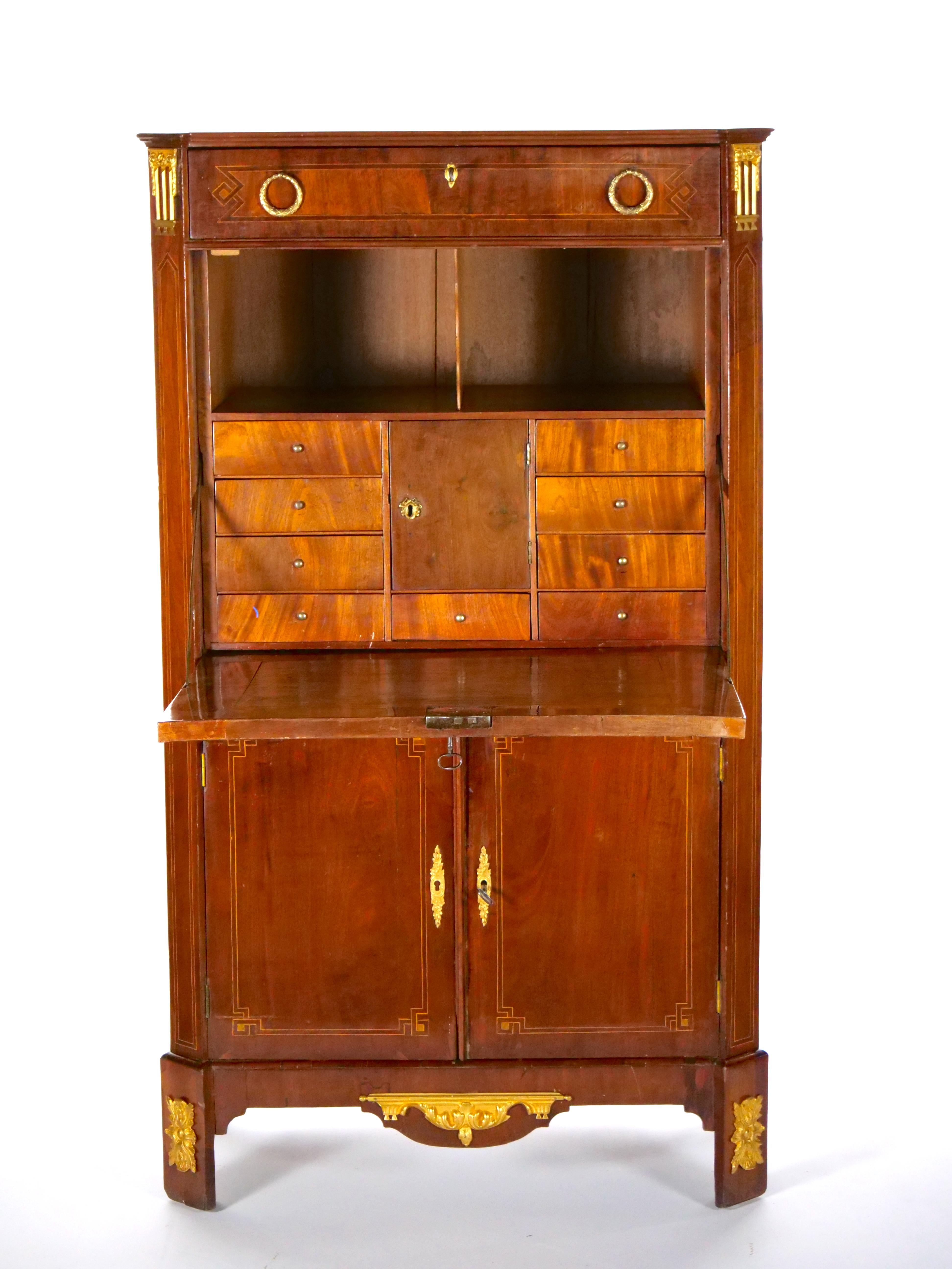19th century mahogany wood neoclassical style bronze ormolu mounted secretary. The secretary is raised on tapered feet mounted bronze ormolu. The center section is fitted with a paneled cylinder opening to a pullout leather insert writing desk