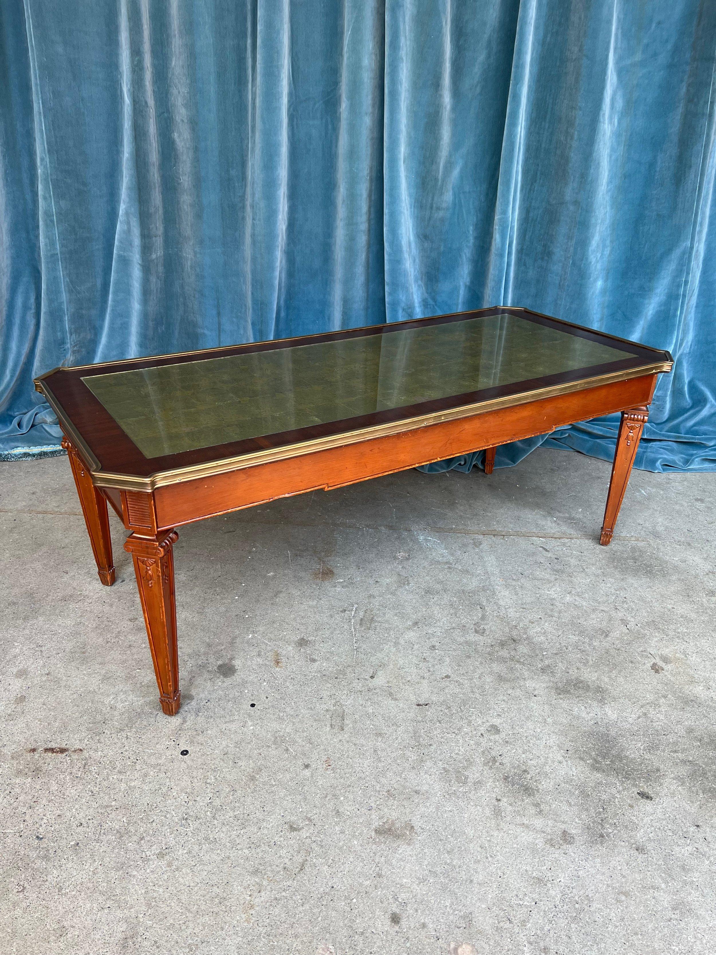 Embrace the splendor of this exquisite Italian neoclassical style coffee table from the 1940s, a stunning centerpiece that commands attention. The base, constructed from solid mahogany, showcases remarkable durability and craftsmanship. Its legs are