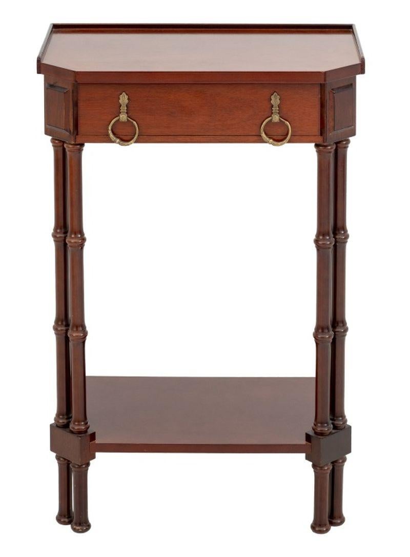 Tavolino a due piani in mogano in stile neoclassico, con cassetto singolo con due maniglie ad anello in ottone e quattro supporti in finto bambù uniti da un piano inferiore. 29,25