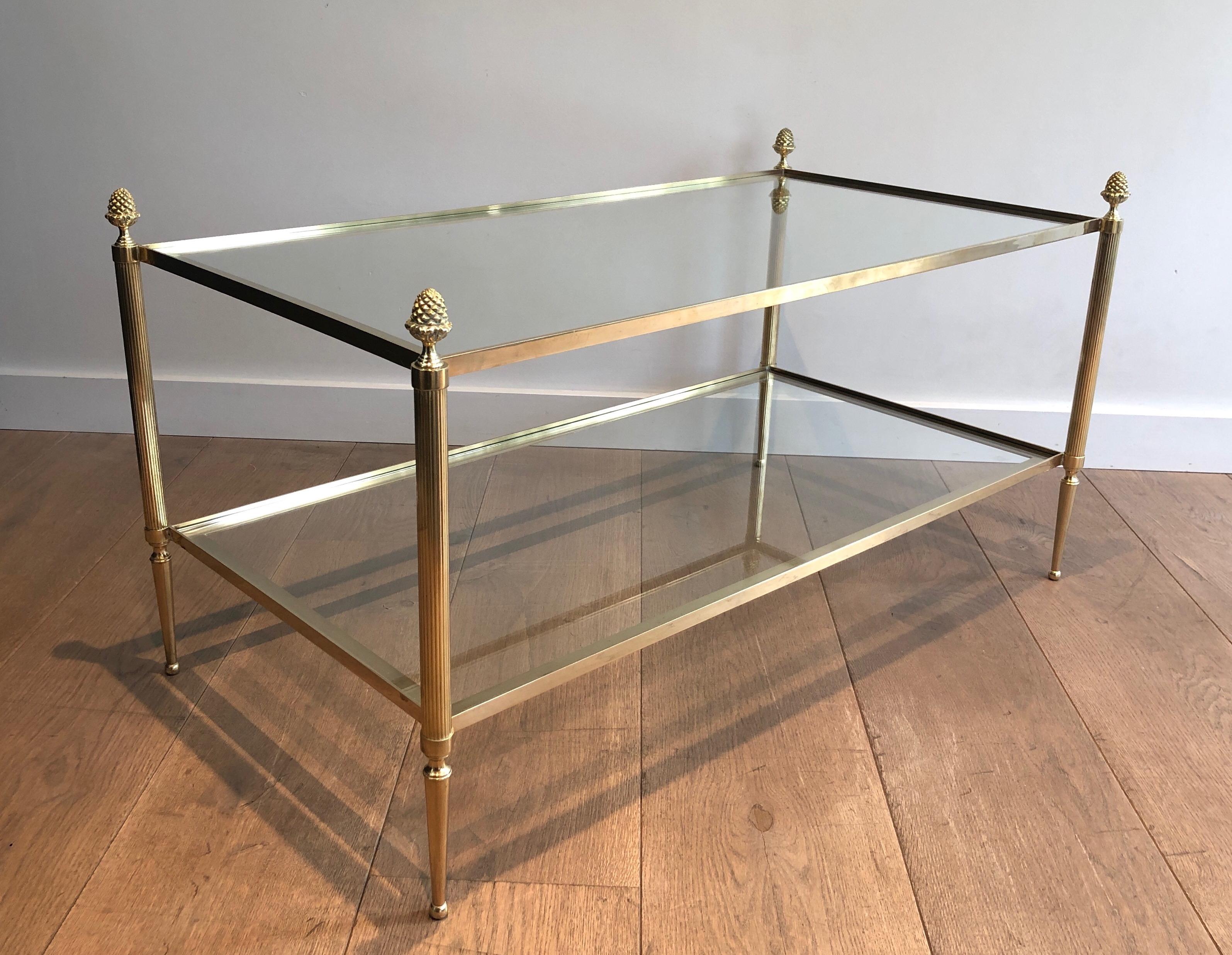 This very nice and elegant coffee table is made of brass with two glass shelves featuring bronze tassels on each corner. This is a French work by Maison Baguès. Circa 1940