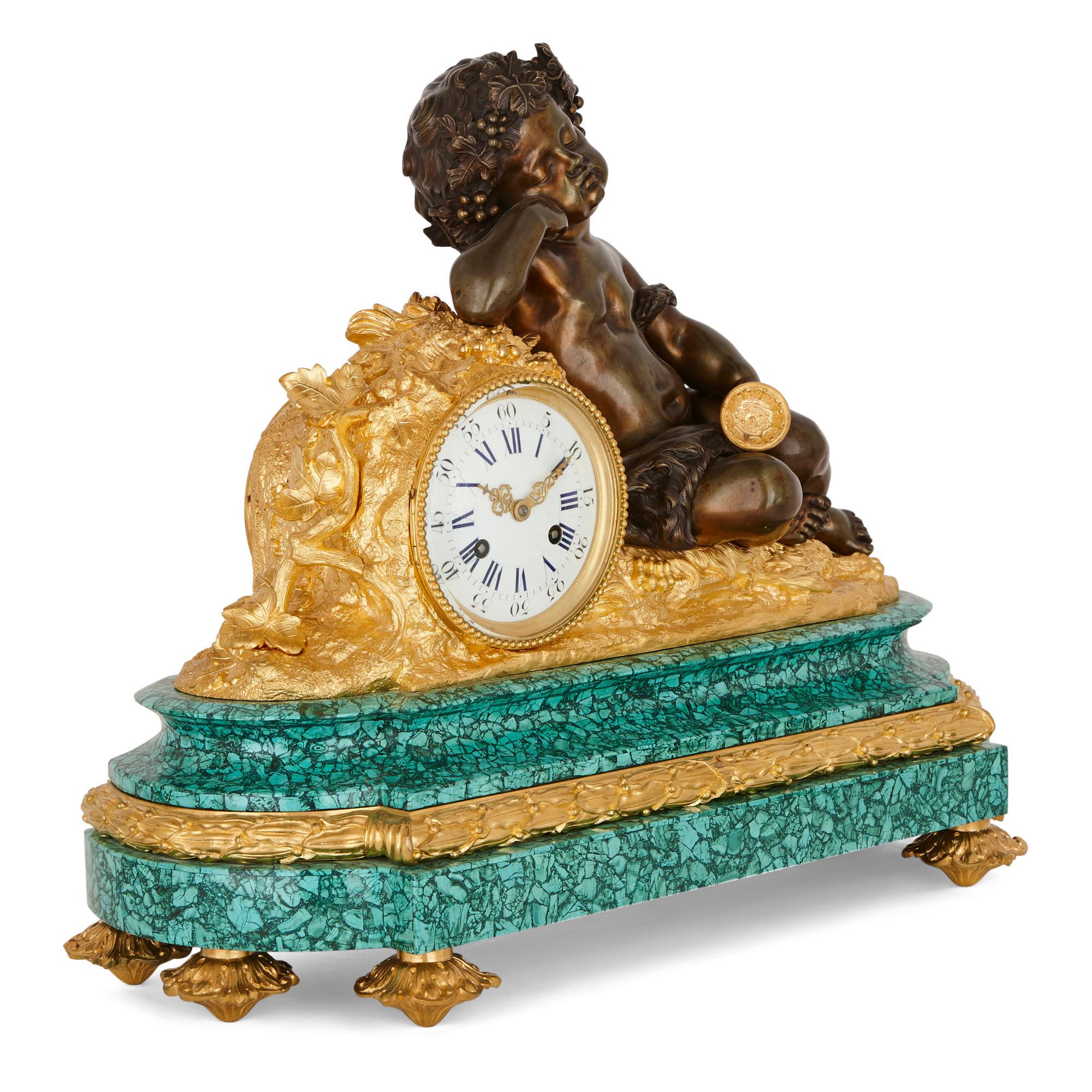 Dieses dreiteilige Set aus Uhr und Kandelaber besteht aus Malachit und ist mit vergoldeten und patinierten Bronzebeschlägen versehen. Der Malachit-Sockel der Uhr steht auf vergoldeten Bronzefüßen. Der Sockel trägt die Uhrentrommel aus vergoldeter