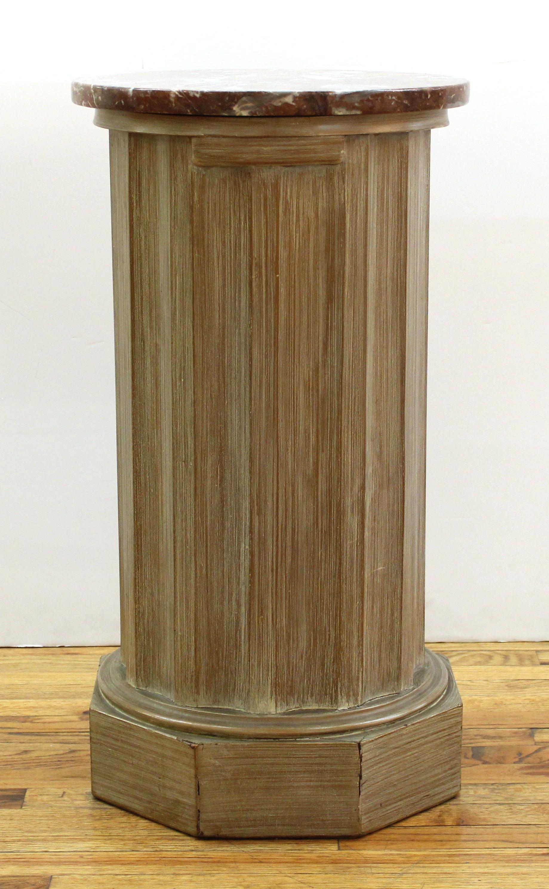 Neoclassical style pedestal stand cabinet in carved wood with round marble top and swing door.