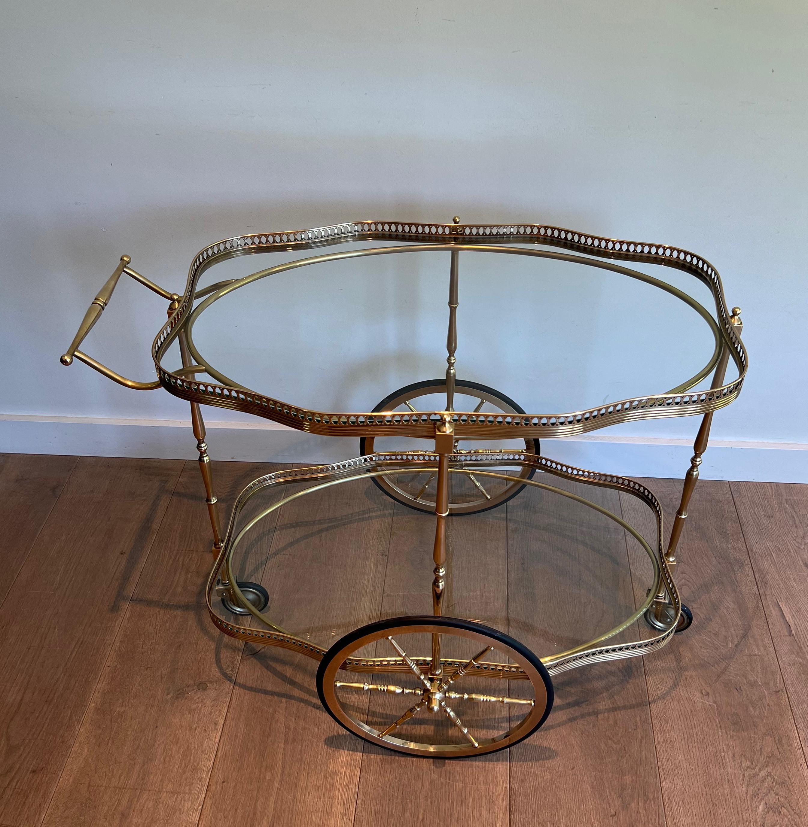 Ce très beau et élégant chariot de bar ovale de style néoclassique est fabriqué en laiton avec 2 étagères en verre transparent. Il s'agit d'un ouvrage français. Circa 1940.