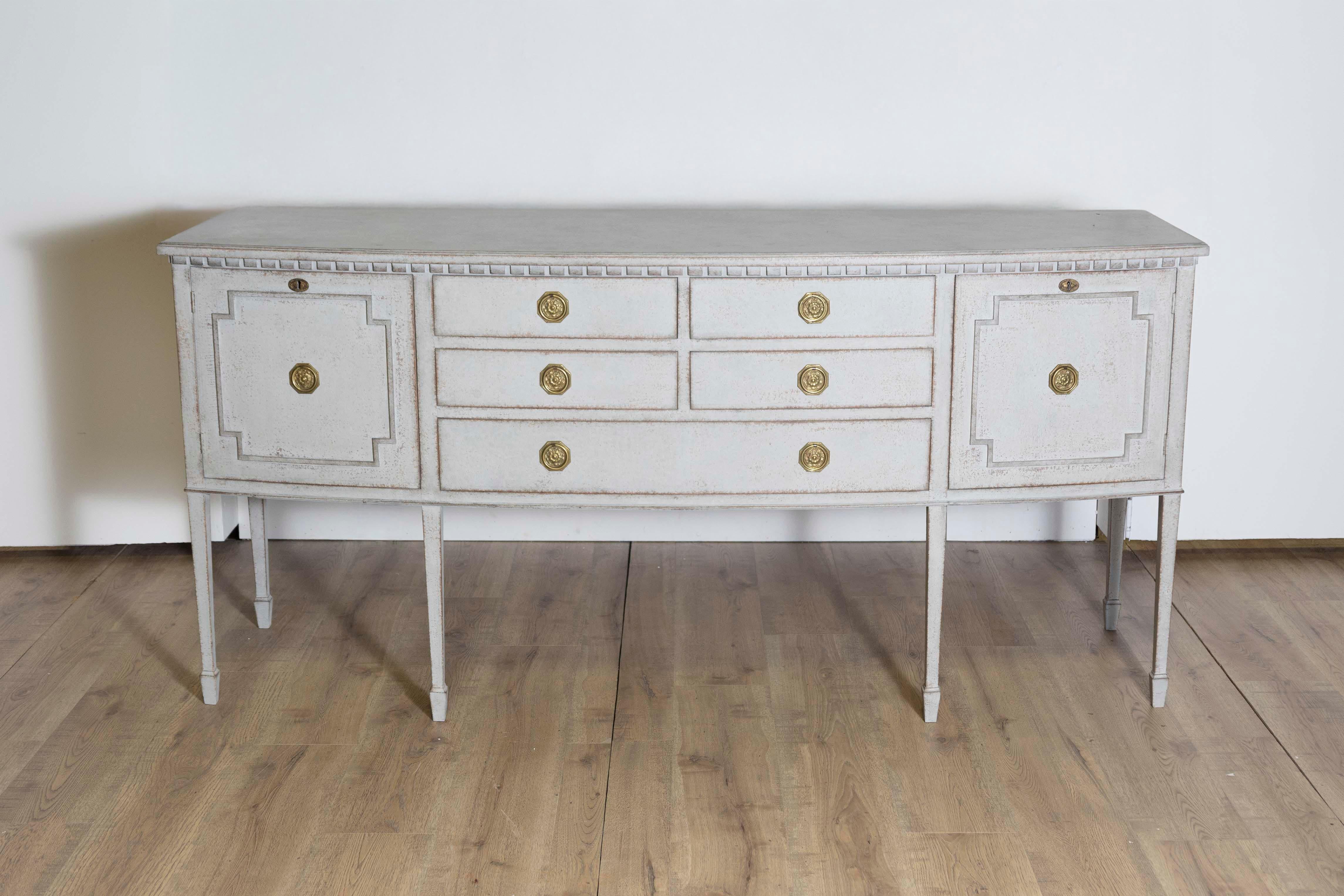 A Neoclassical style Swedish painted wood bow front sideboard from the 20th century with five drawers flanked by two doors. Immerse yourself in the elegance of the past with this Neoclassical style Swedish painted wood bow-front sideboard, dating