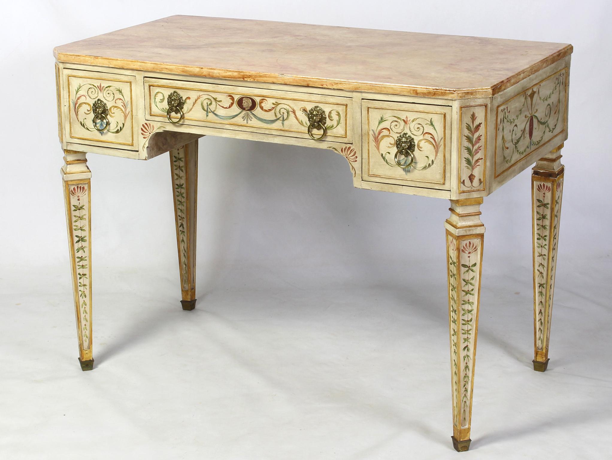 A small and elegant Neoclassical style painted desk or dressing table dating from the 1940s with rose colored faux marble top over three elaborately decorated drawers resting on square tapering legs painted with flowering vines terminating in brass