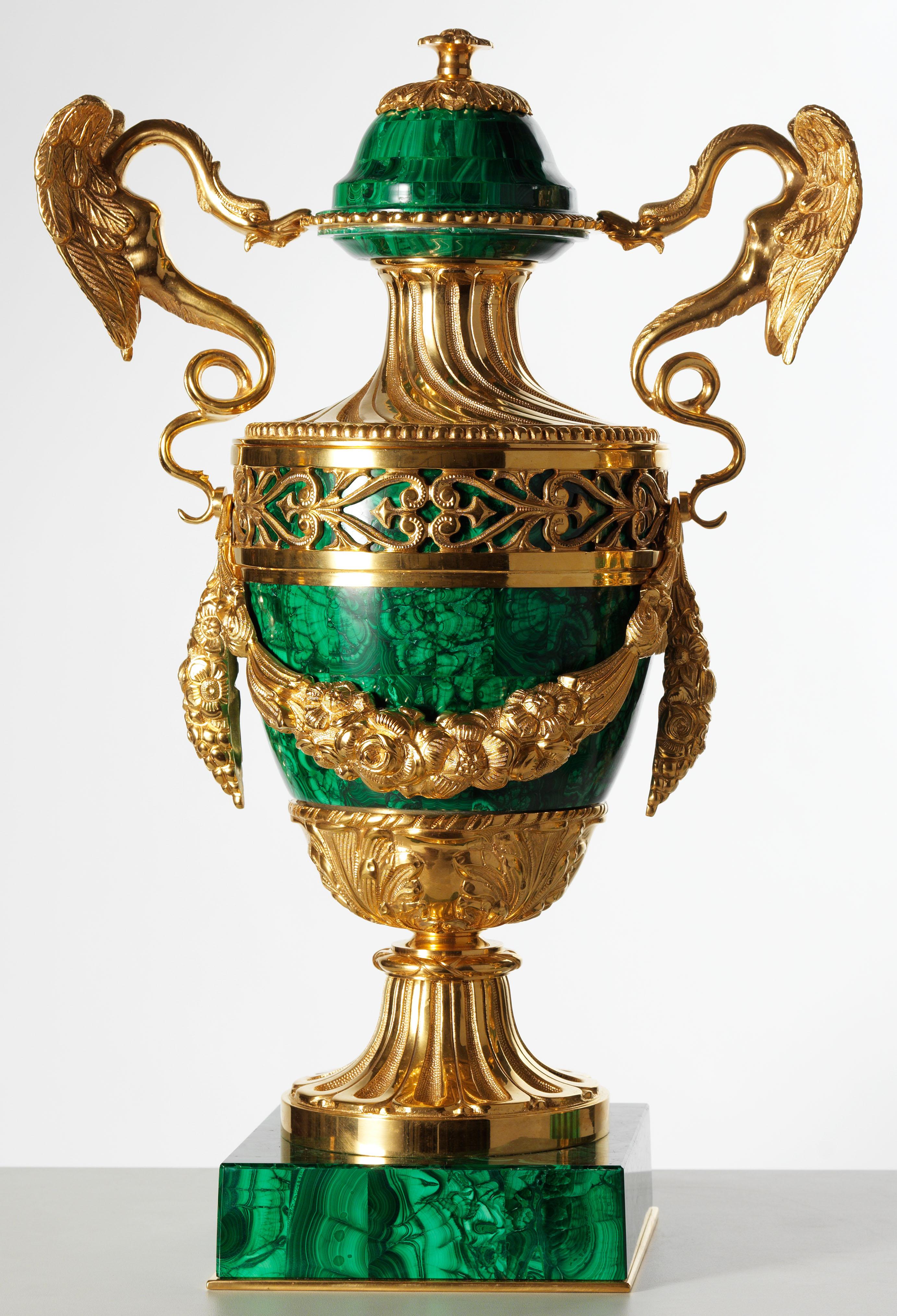 Pair of neoclassical style gilt bronze and malachite urns. They have an ovoid form veneered with malachite all-over. The urns feature a full chiseled gilt bronze mounts: the most impressive and artistic elements are the twin dragon-form handles,