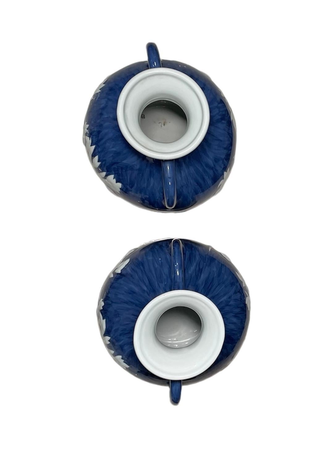 Questa è una coppia di vasi blu di Maitland Smith. Raffigura una coppia di vasi a forma di urna di colore blu reale con manici decorati con un rilievo bianco di scene romane di tipo neoclassico con coppie di nudi e amorini. Sotto una delle basi c'è