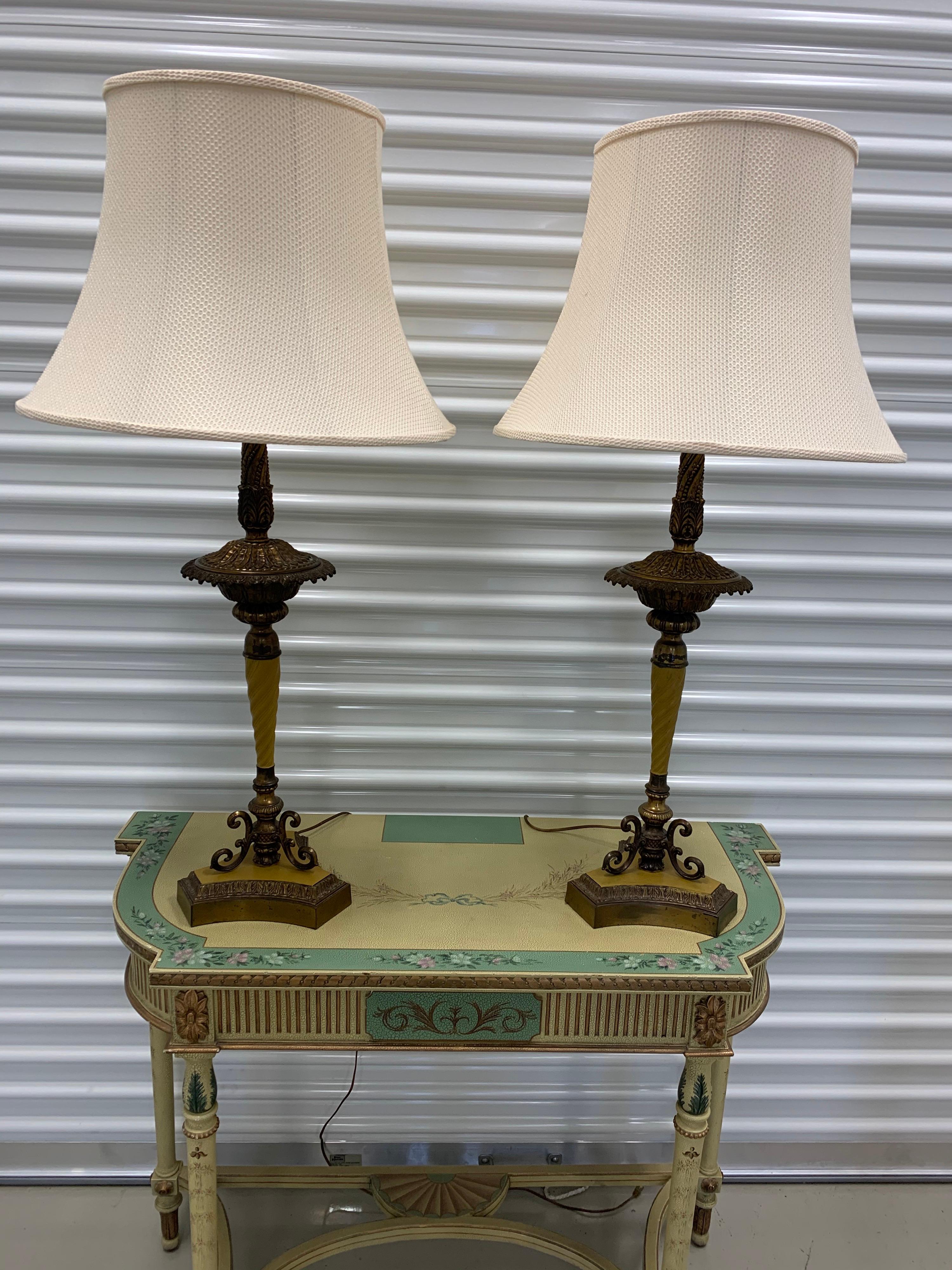 Elegant pair of neoclassical two light table lamps. They are hand painted and the color is unusual, almost a light butterscotch - see pictures. Shades are original and a cream color. Two bulbs sockets in each matching lamp. Wired for USA and in