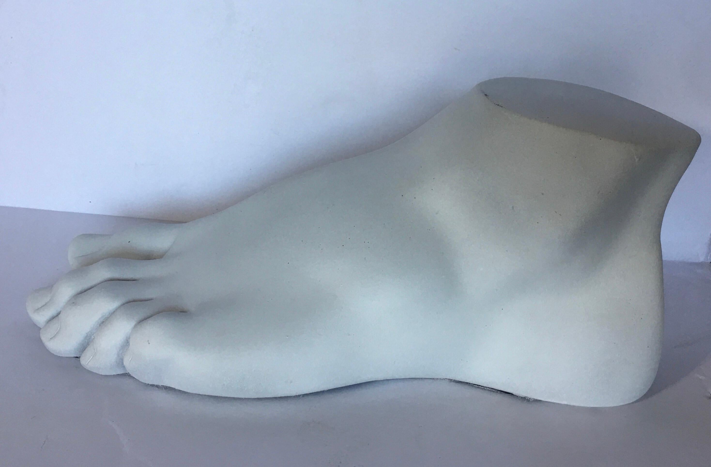 Neoclassical Roman style cast foot fragment sculpture in a matte white plaster finish. An interesting tabletop accessory for any Hollywood Regency interior. In the style of Piero Fornasetti.