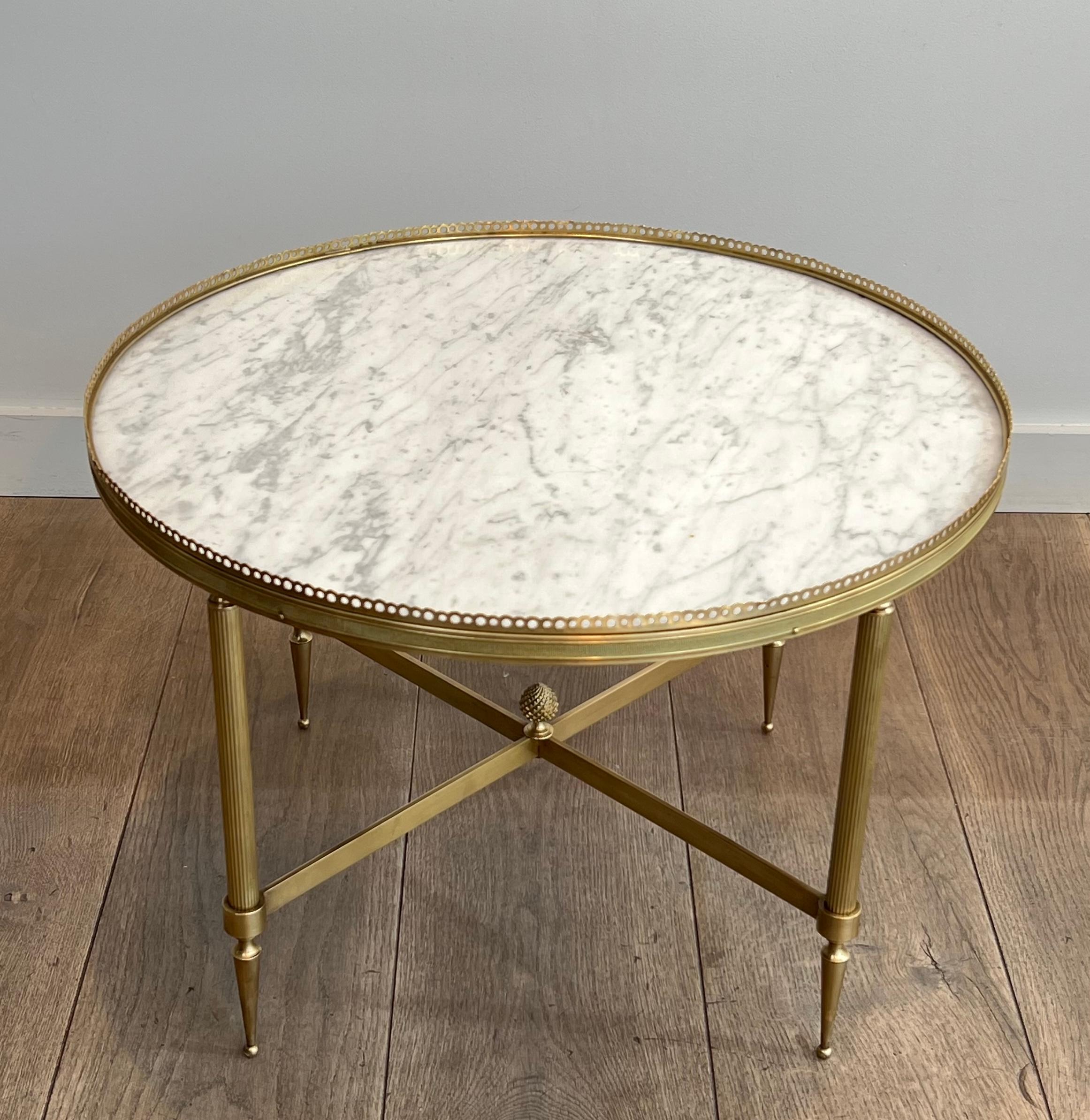 Questo tavolino rotondo in stile neoclassico è realizzato in ottone con un piano in marmo bianco di Carrara. Questa è un'opera francese di Maison Jansen. Circa 1940