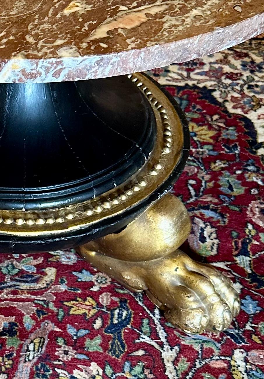 Tavolino da caffè con piedistallo in legno con piano in marmo in stile neoclassico 

Antico tavolino rotondo con piano in marmo Antico Rosso e base in legno ebanizzato e dorato. Questo tavolo rotondo molto particolare ha una base dalla forma
