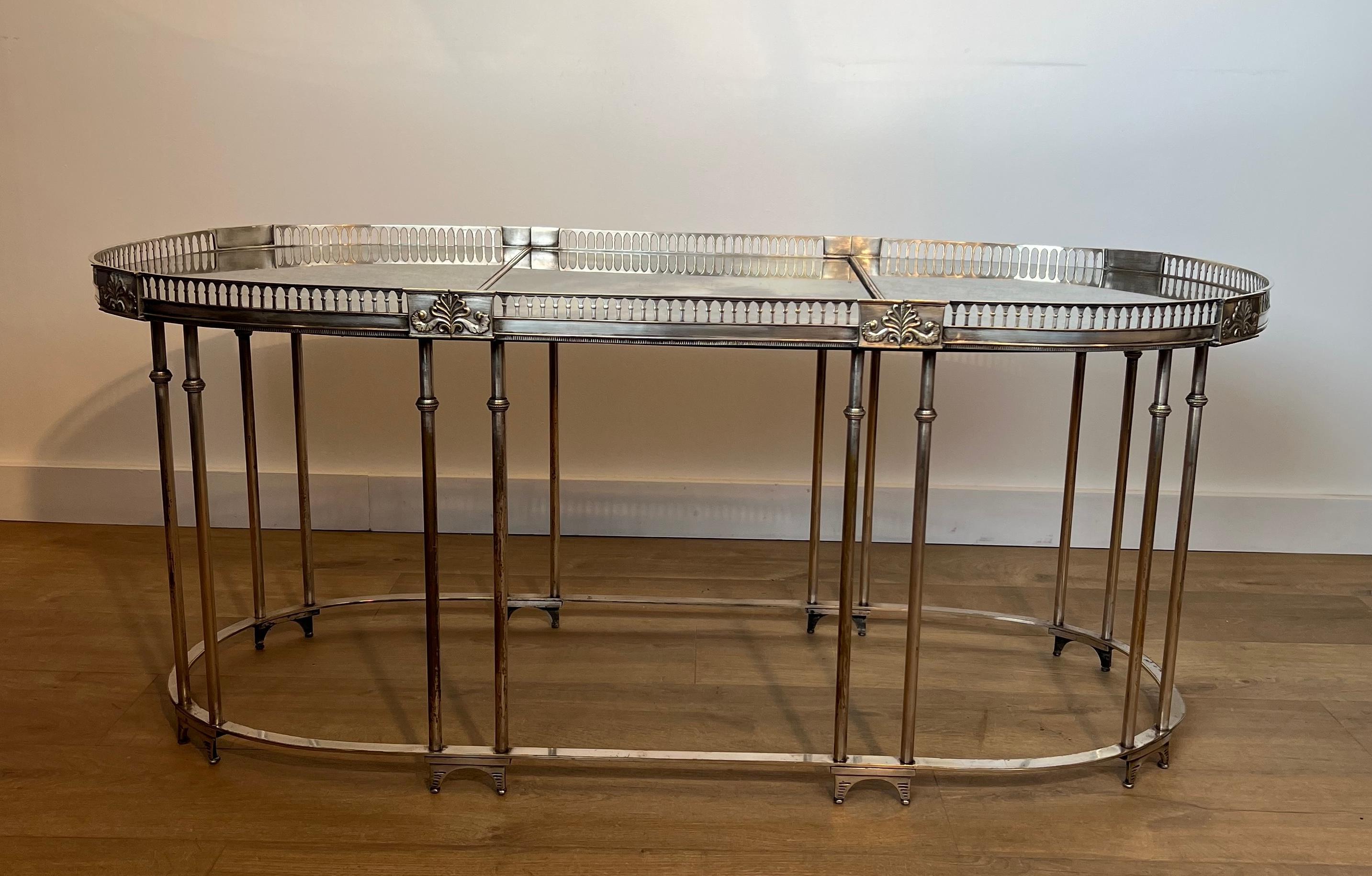 Questo tavolino da caffè in stile neoclassico, molto bello e unico, è realizzato in ottone placcato argento con decorazioni e piani a specchio Antique Mirror (lo specchio centrale è rovinato e potrebbe essere sostituito). Si tratta di un'opera