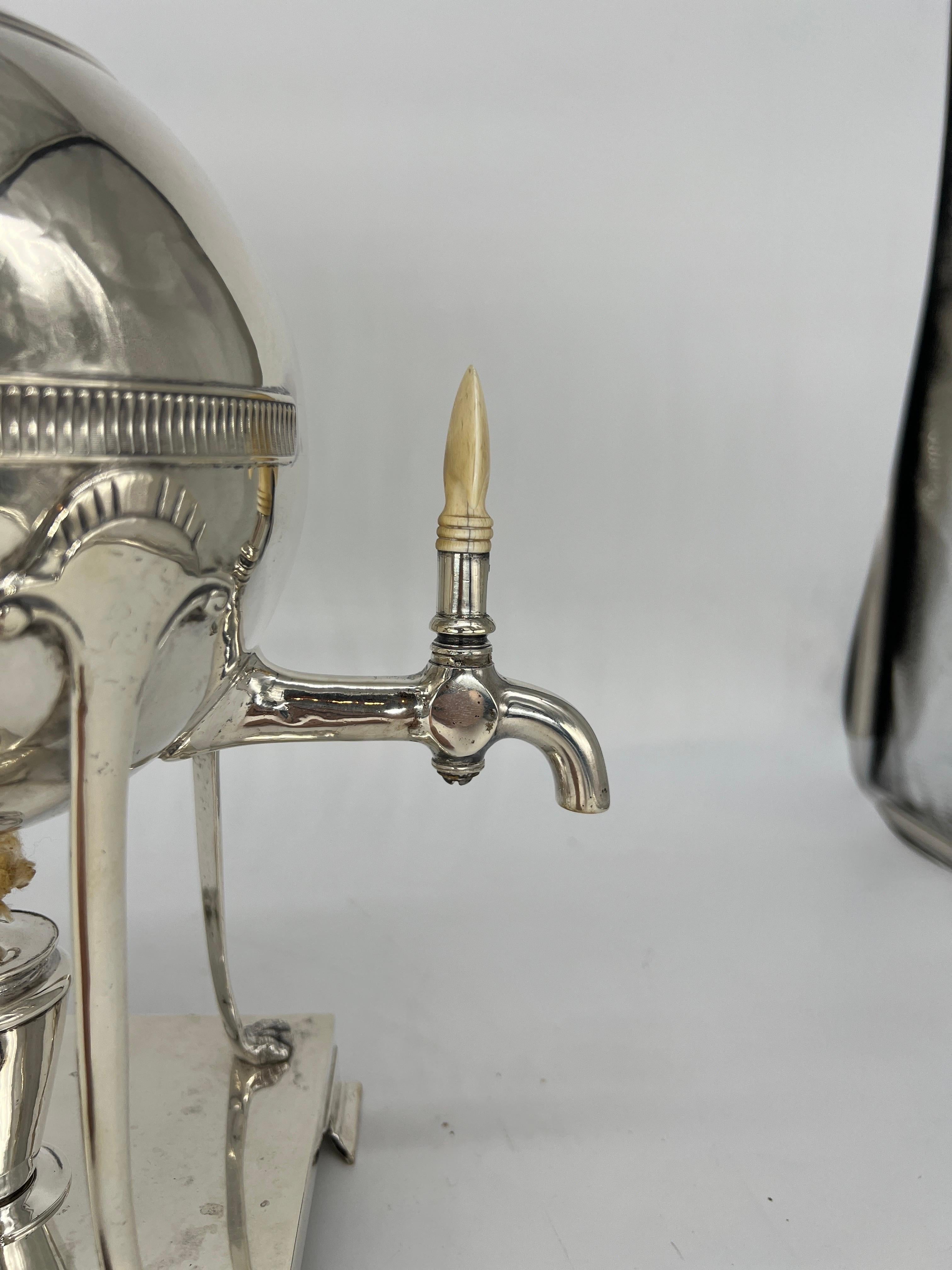 Thomas Kirkpatrick (American - New York, 1832-1920). 
A very fine quality silver plated hot water urn in the neoclassical style. Having a round main body with a reeded band, lion form door knocker handles, four curved supports with paw feet and a