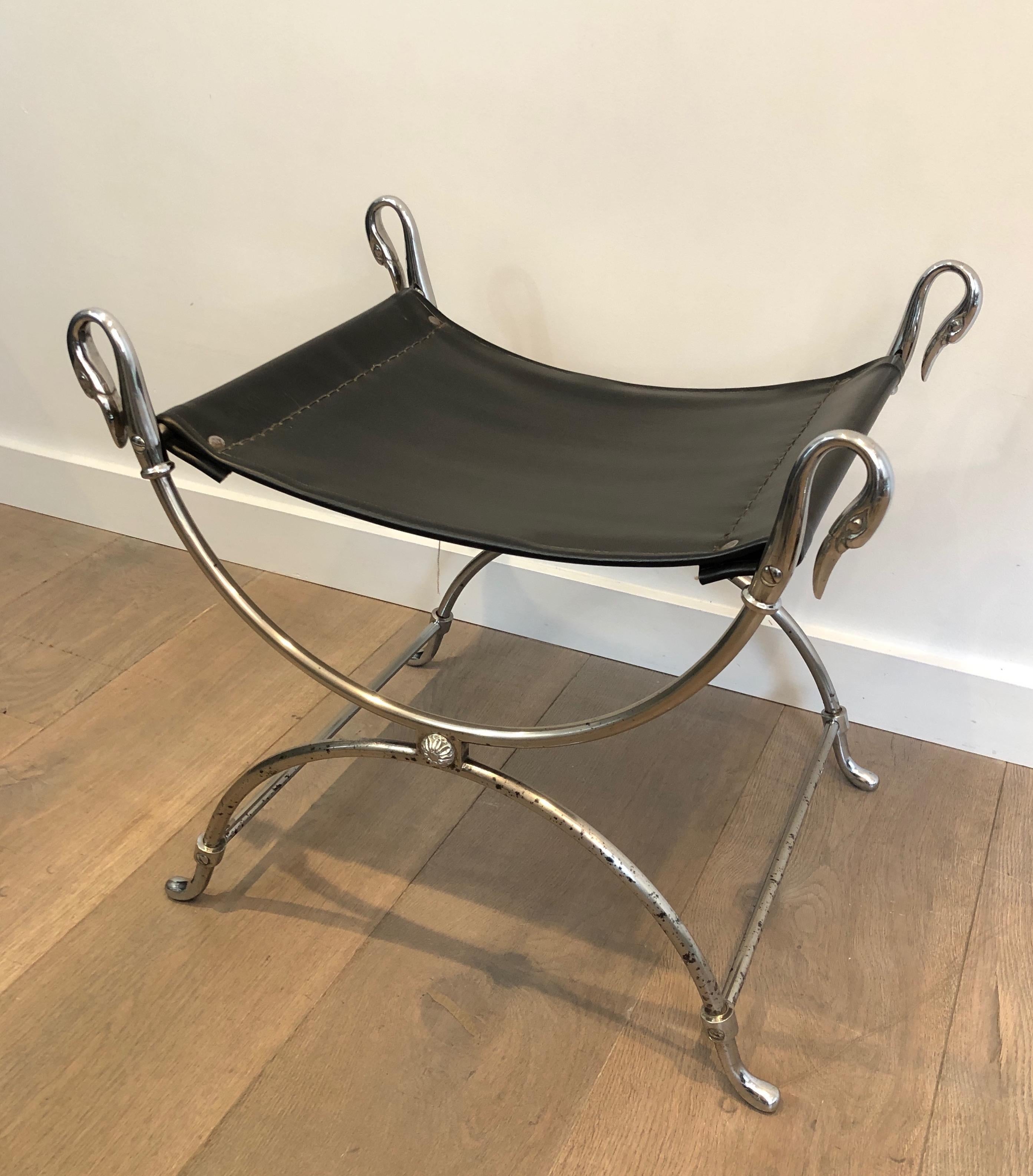 Questo sgabello in stile neoclassico molto bello e decorativo è realizzato in acciaio argentato con teste di cigno. La placcatura in argento manca in alcune aree. La seduta è in ecopelle nera. Questa è un'opera francese. Circa 1940