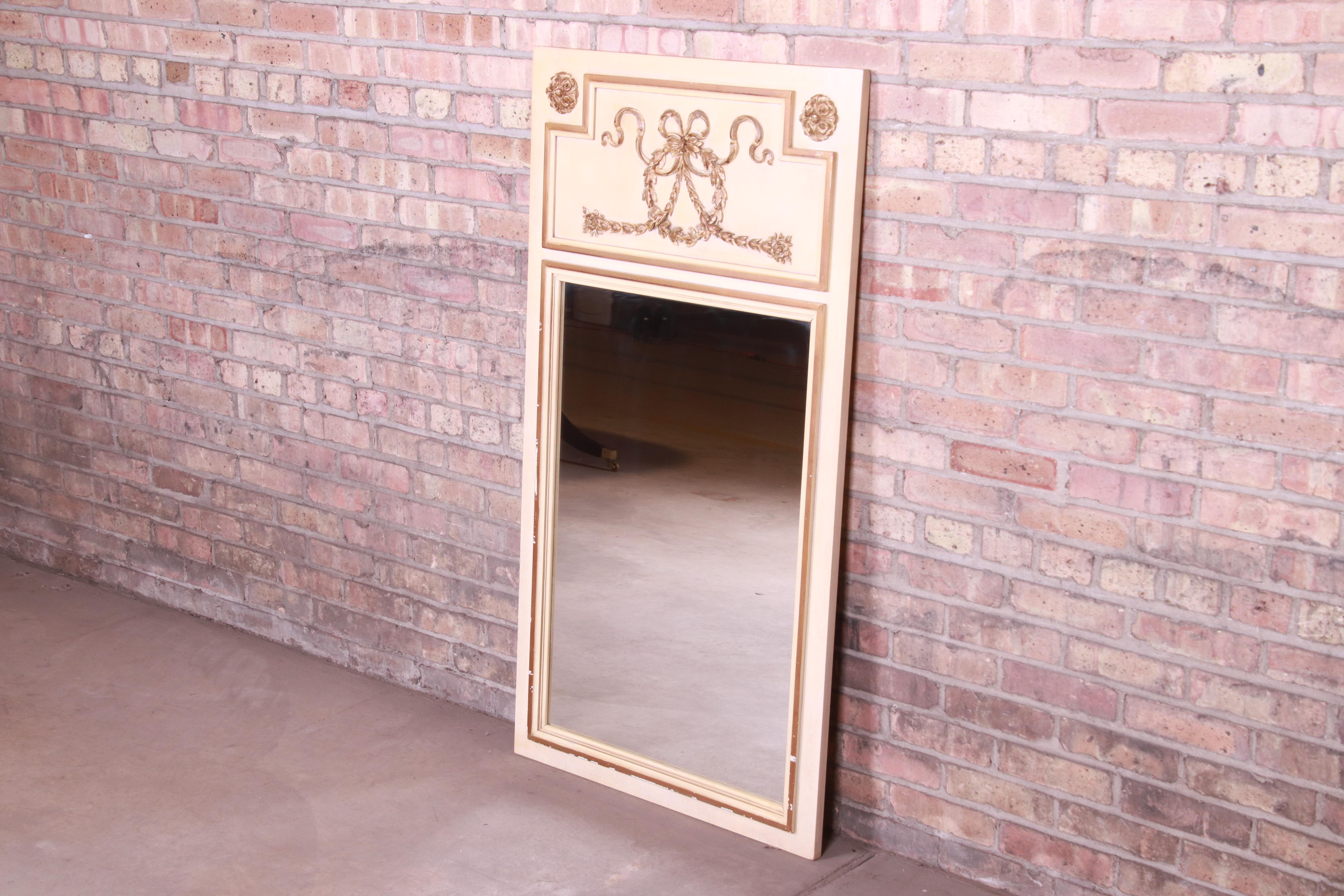 A gorgeous neoclassical style framed wall mirror

By J.L. Metz

USA, circa 1960s

Painted cream solid wood frame, with gold gilt trim and details.

Measures: 28.75