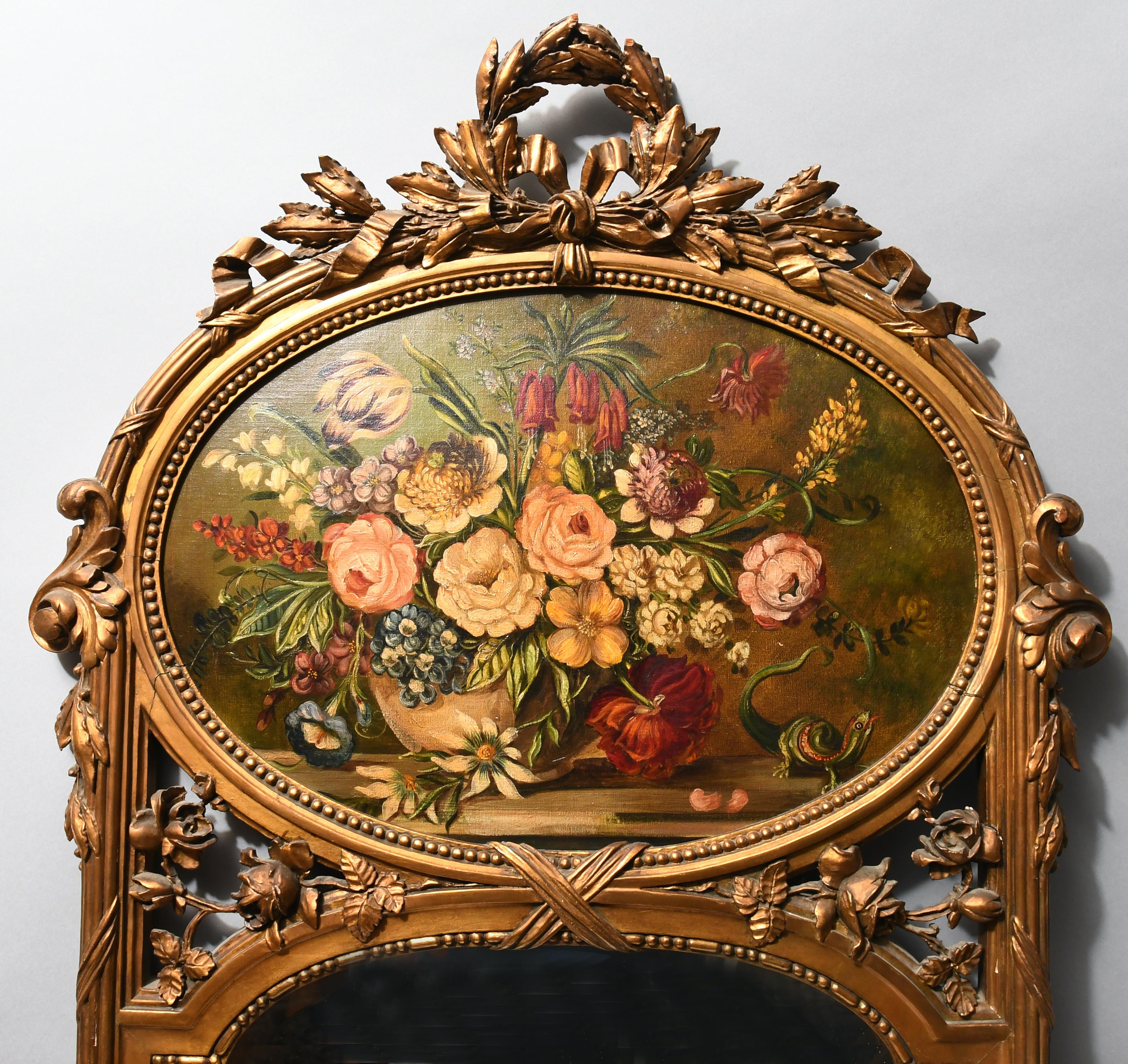 Ein Wandspiegel aus vergoldetem Holz in Bogenform mit einer Lorbeergirlande, die als Abschluss einen Kranz bildet. Der Rahmen um den Spiegel und das Gemälde ist geriffelt und mit einigen Akanthusblättern verziert. Zwischen dem Gemälde und dem