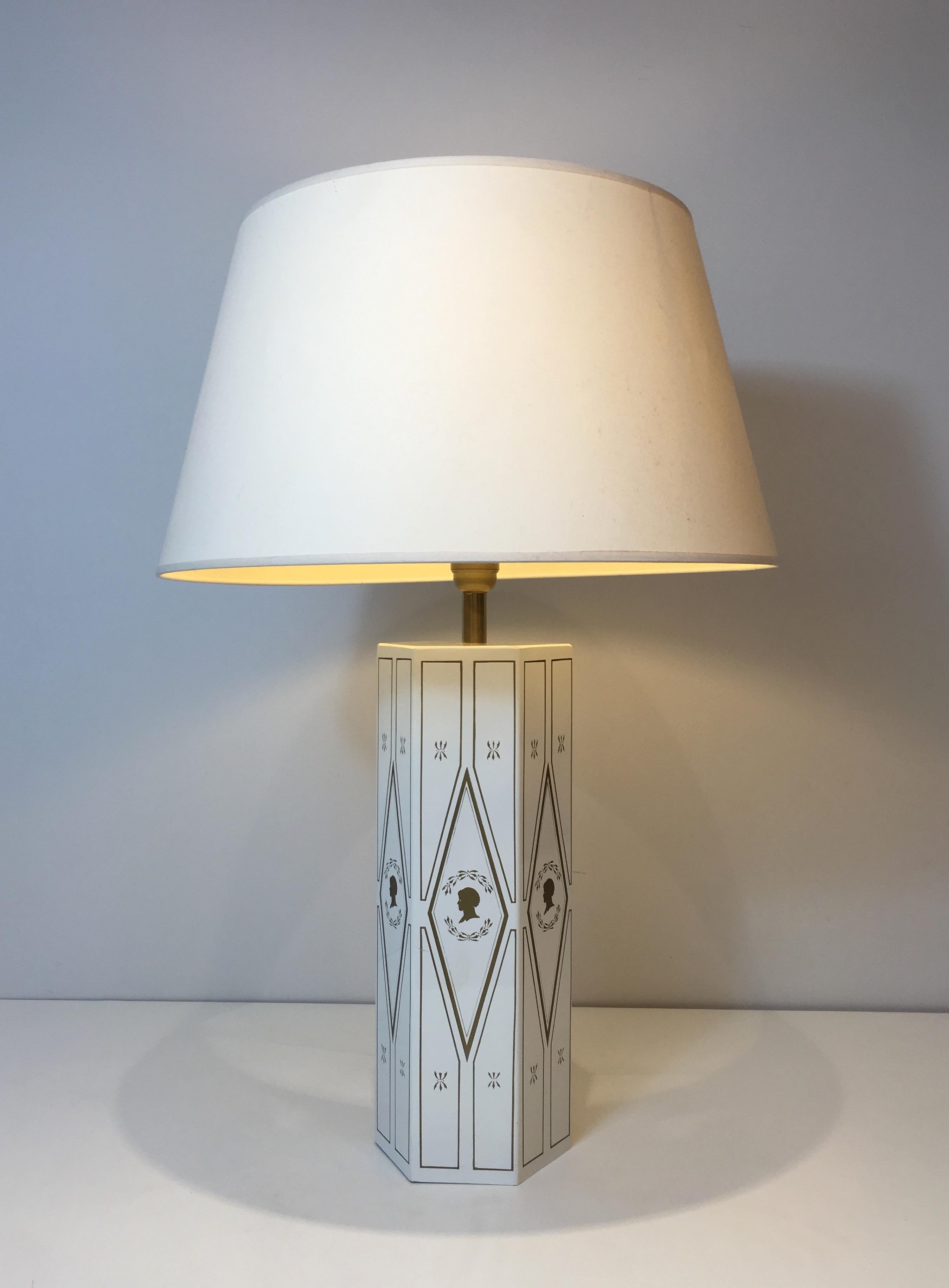 This decorative neoclassical style table lamp is made of white lacquered sheet metal with gilt decors. This is a French work, circa 1970.