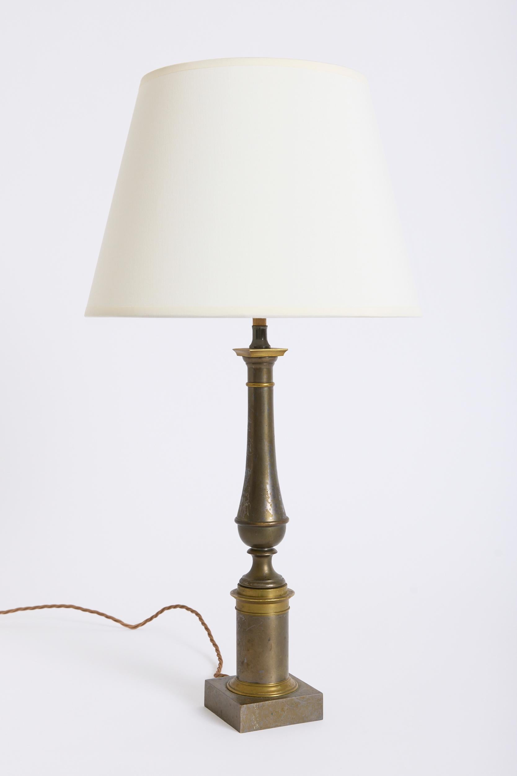 A Neoclassical bronze table lamp
France, Circa 1950
With the shade: 62 cm high by 36 cm diameter
Lamp base only: 44 cm high by 8.5 cm wide by 8.5 cm depth
