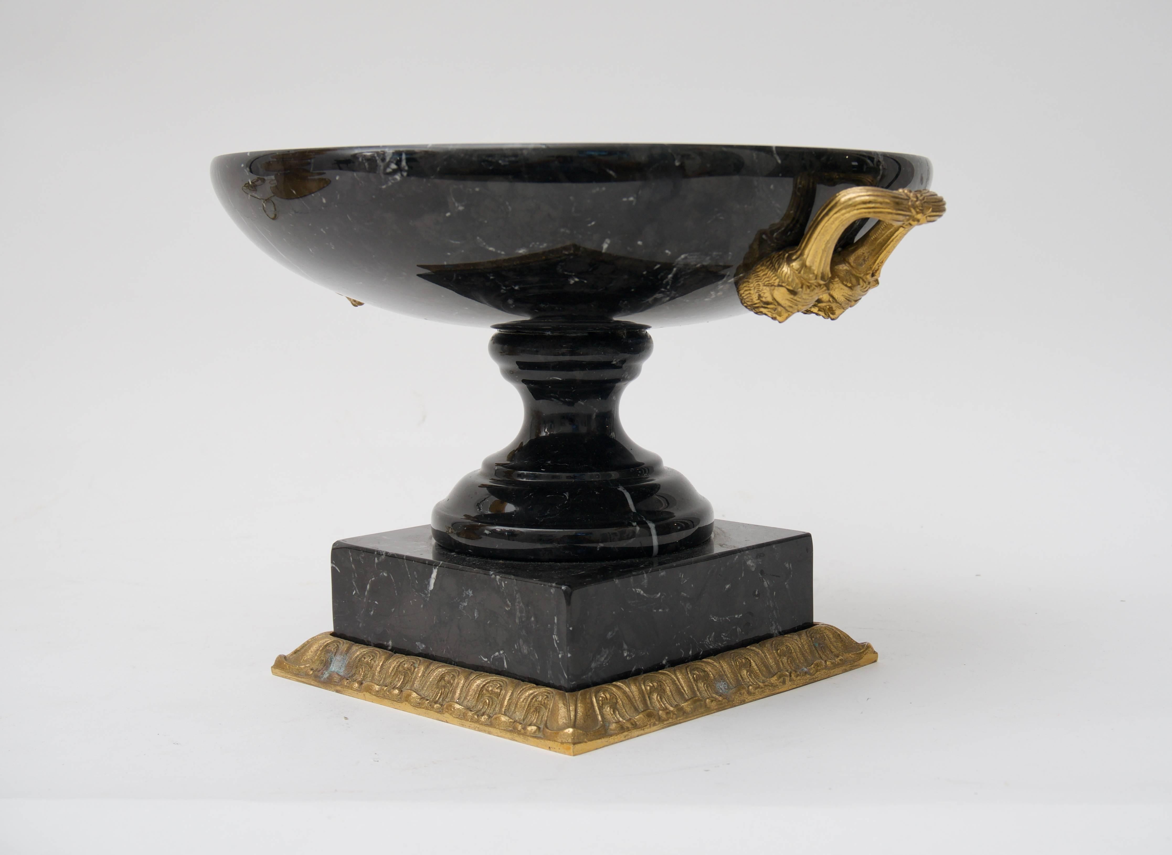 This stylish piece is very much in the style of pieces created by Maitland Smith and that Piranesi documented in his 18th century engraving of classical places and items. The piece is detailed with bronze mounted handles with figural faces and base