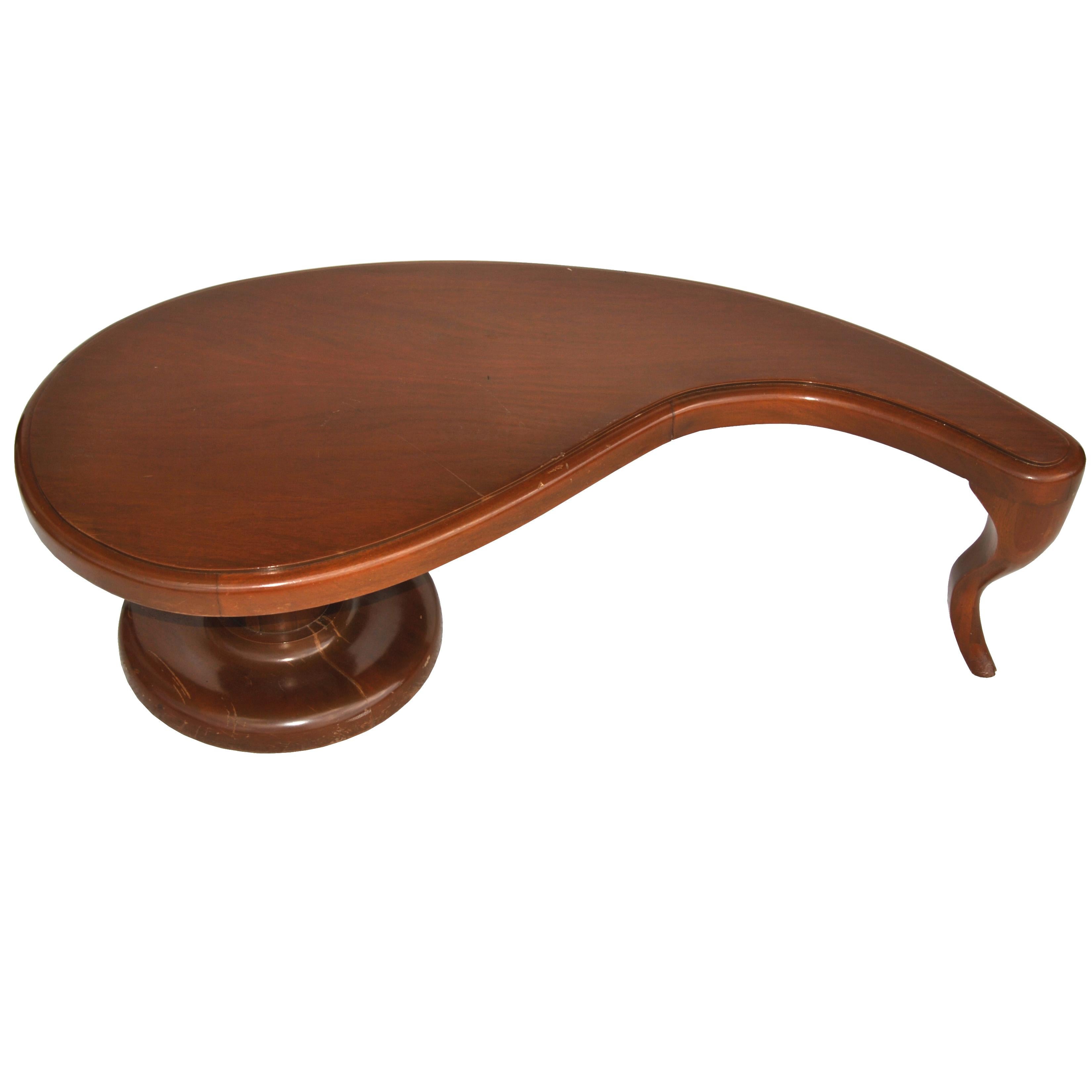 Neoclassical style coffee table in the manner of John Tavis,
1950s
 

An interesting design featuring an organic shaped top paired with a classical pedestal and sabre leg in a rich mahogany.