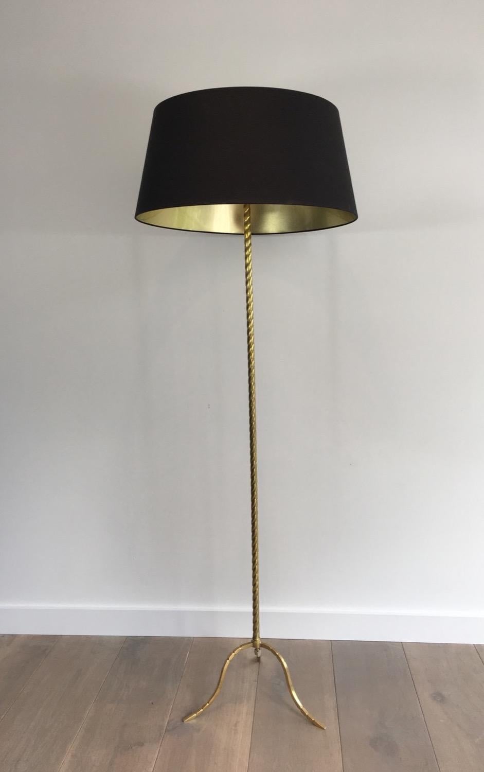In the style of Maison Jansen. Neoclassical twisted brass floor lamp with a tripode base. French, circa 1960.