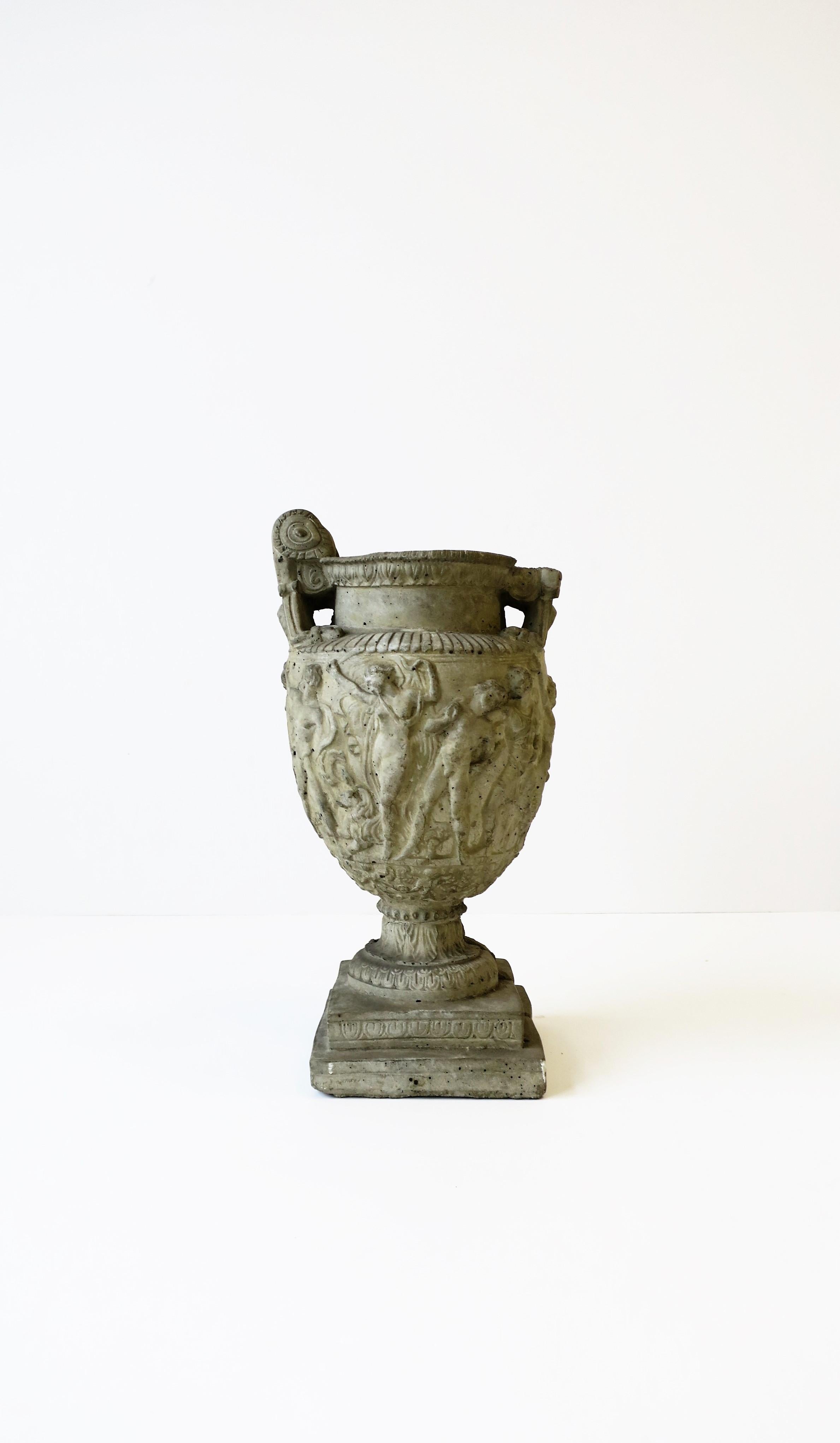 A neoclassical urn sculpture piece or planter jardinière, circa 20th century. A beautiful piece made from cement/concrete with all the details of the neoclassical style. Piece can be use as a decorative urn sculpture or as a planter as show in