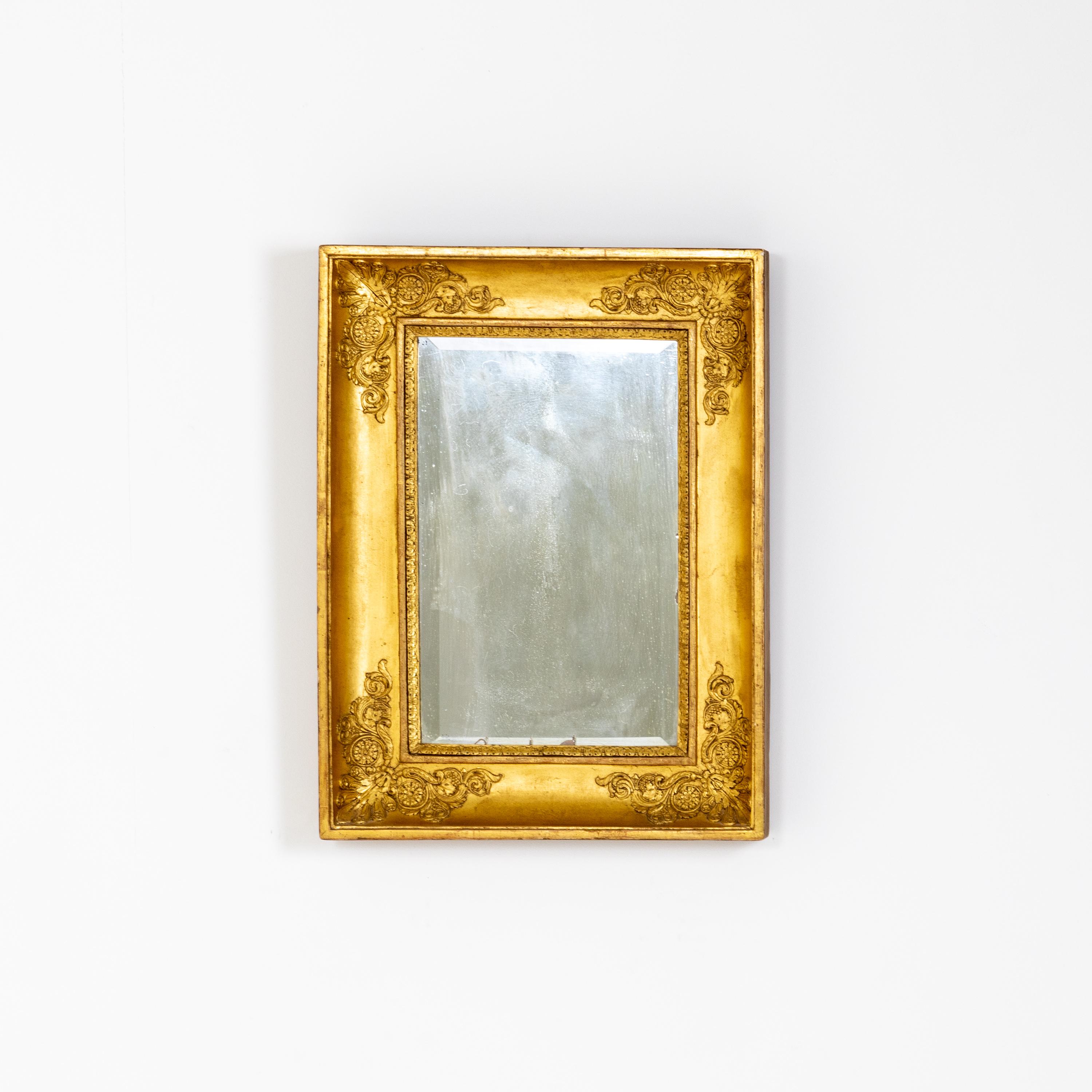 Rectangular wall mirror in giltwood with stucco accents.