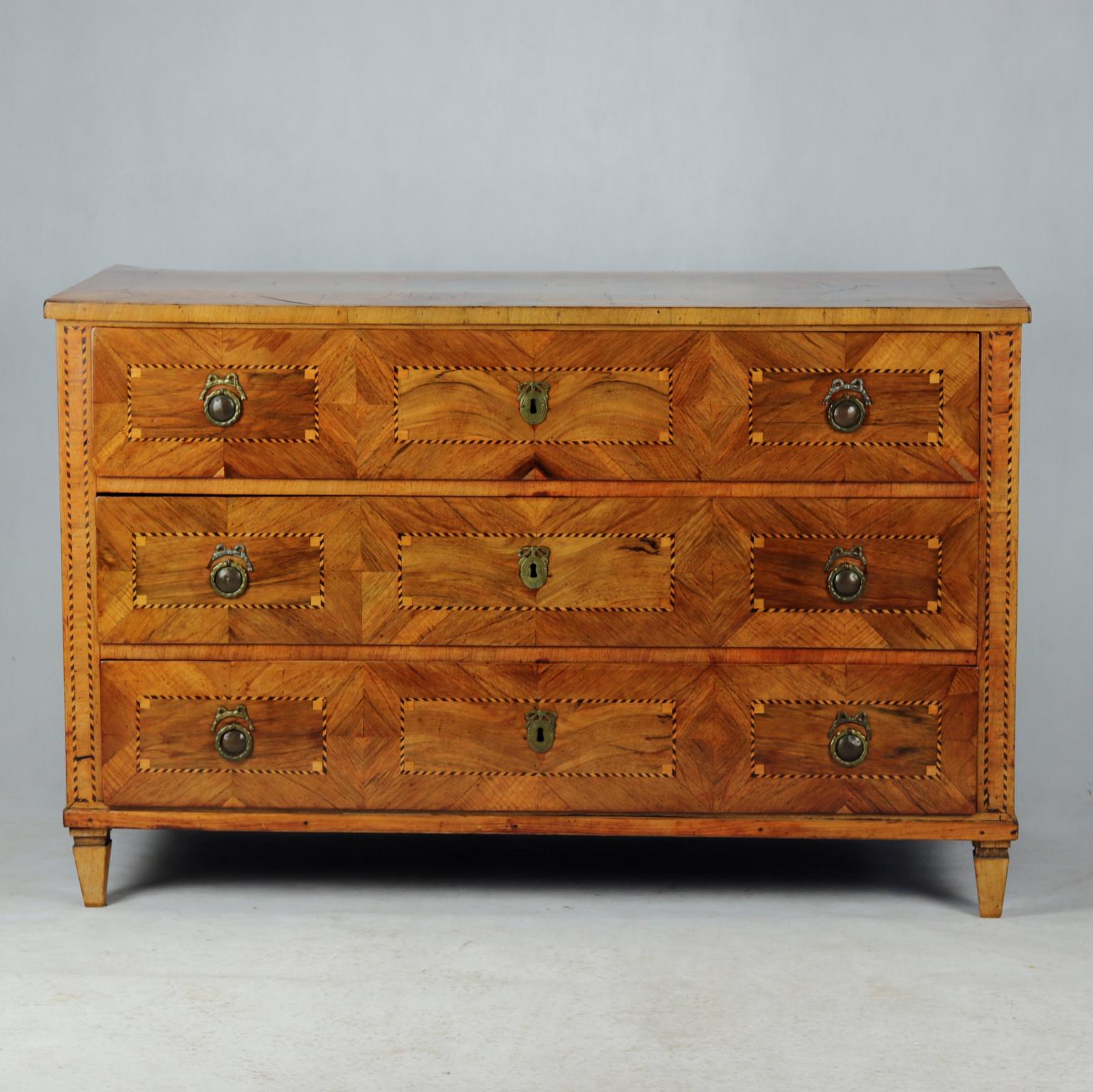 This German chest of drawers was built around 1800 in Germany. The body of the chest is made of pine wood and reworked veneered with walnut. The upper is decorated with a beautiful strip. The body with three drawers is decorated with edging and