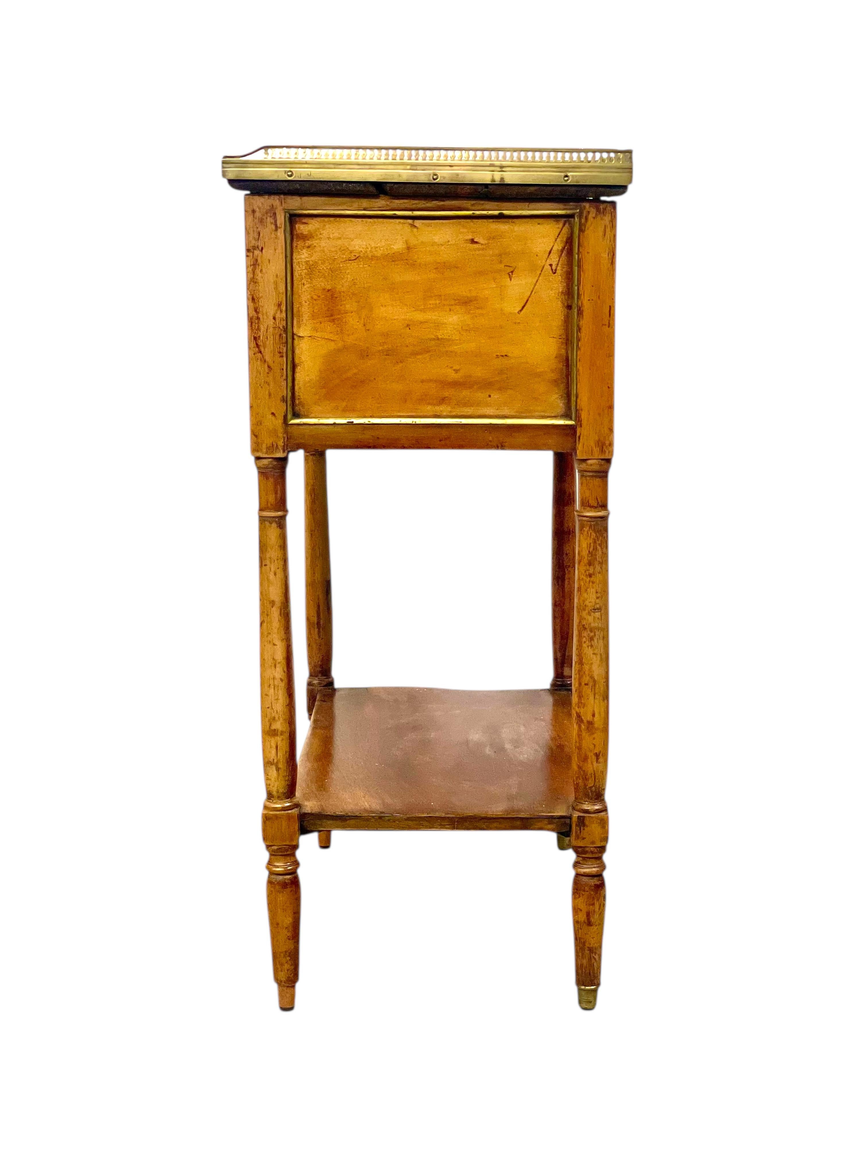 This elegant side table or Nightstand in solid walnut is a beautiful example of late 18th century French craftsmanship. The refined silhouette and detailing suggest a transitional piece between the Louis XVI and Directoire periods, with neoclassical