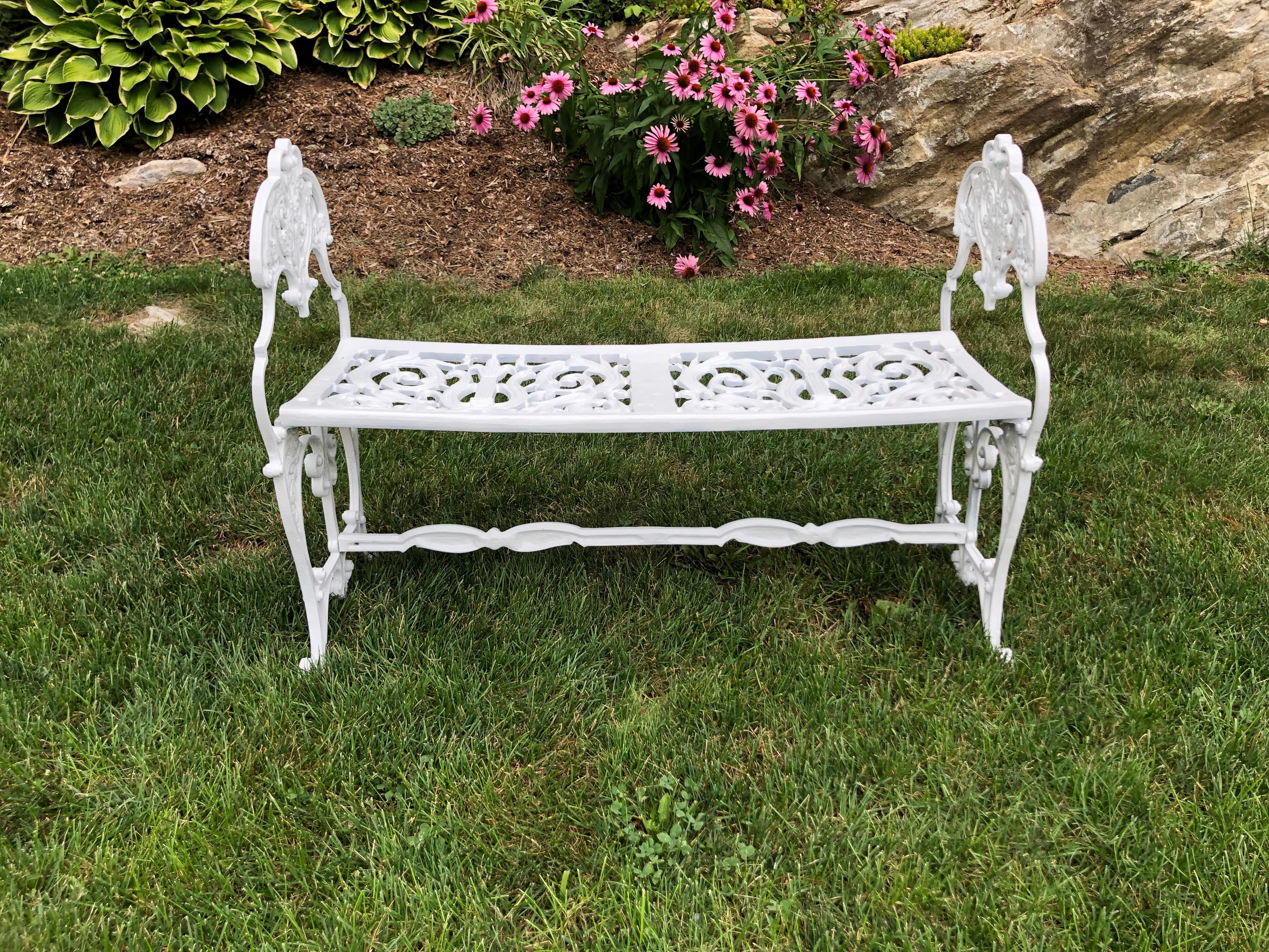 Neoclassical white garden bench. Perfect size to move easily around your garden. Petite and highly decorative with all of its scrolls and embellishments. Recently refinished and repainted. Love seat size, Ideal for two. This item can parcel ship.