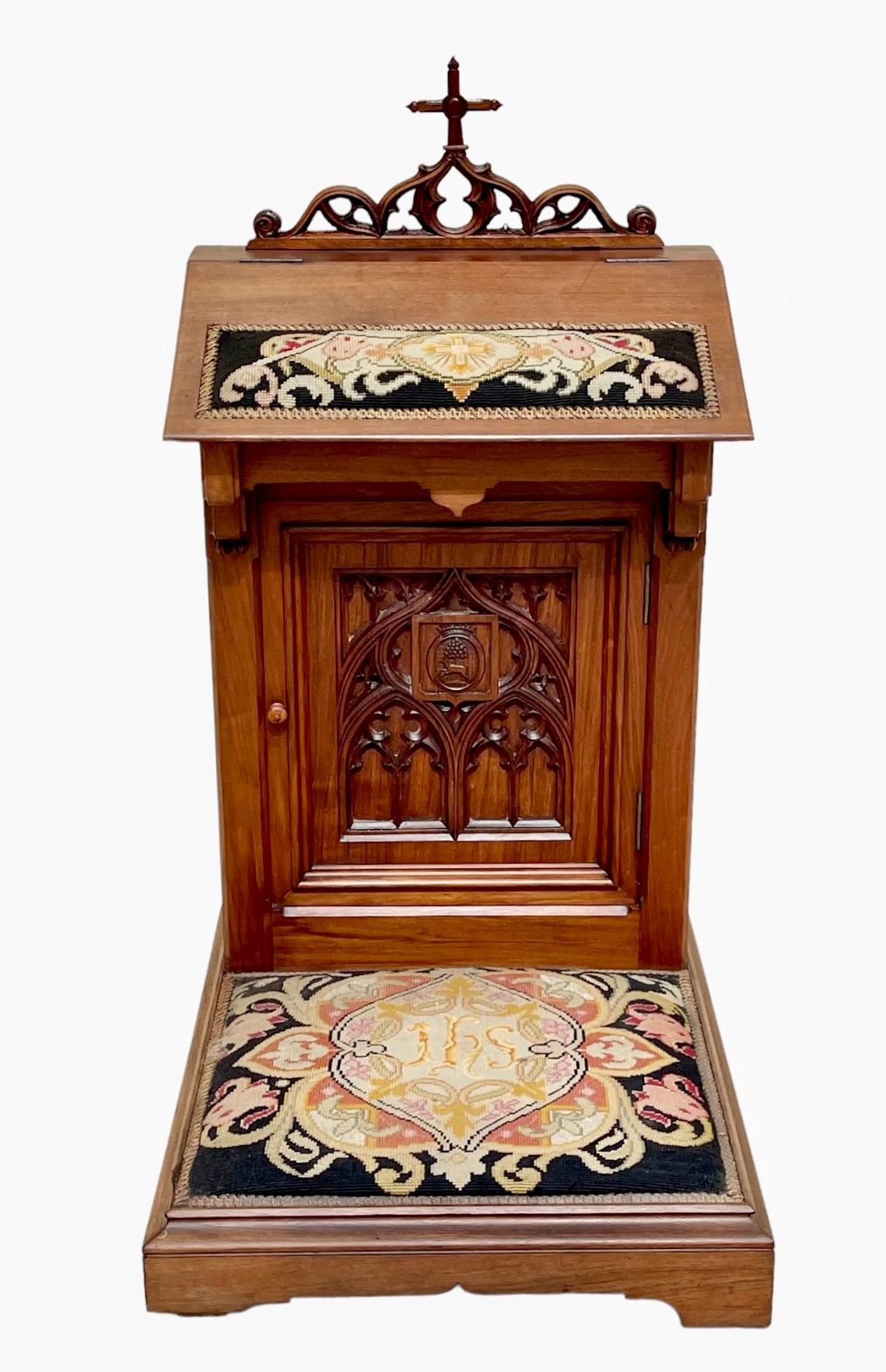 Pray to God in carved walnut in Gothic style opening to a door and a desk shelf It has an old tapestry with small dots French work from the 19th century We can notice on the door a coat of arms with the coat of arms of a French