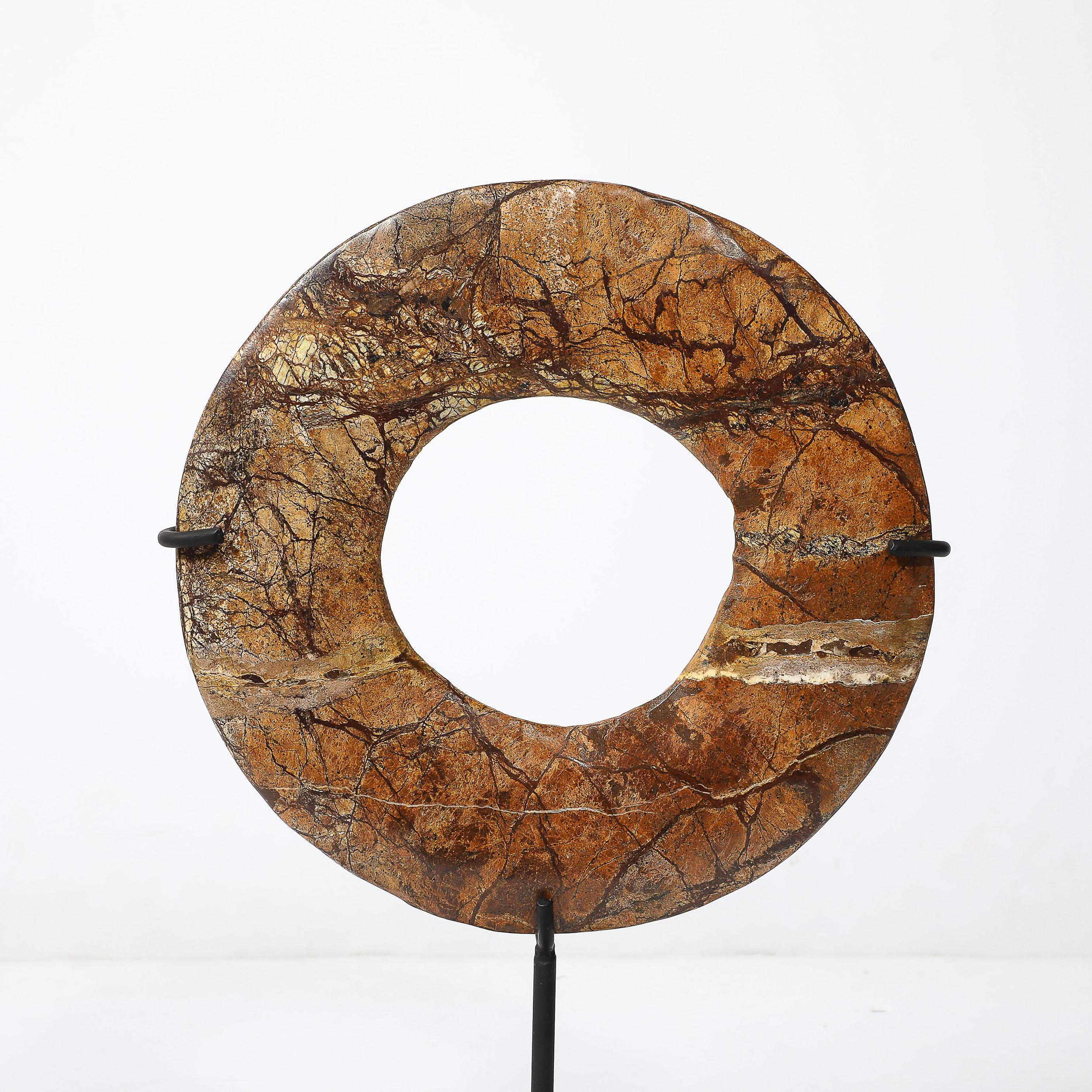 This exquisite red soapstone Bi disc is a remarkable artifact from Neolithic China, dating back to the 3rd millennium BC. Set on a modern iron base, the disc reflects the timeless beauty and mystery of ancient craftsmanship. Bi discs, characterized