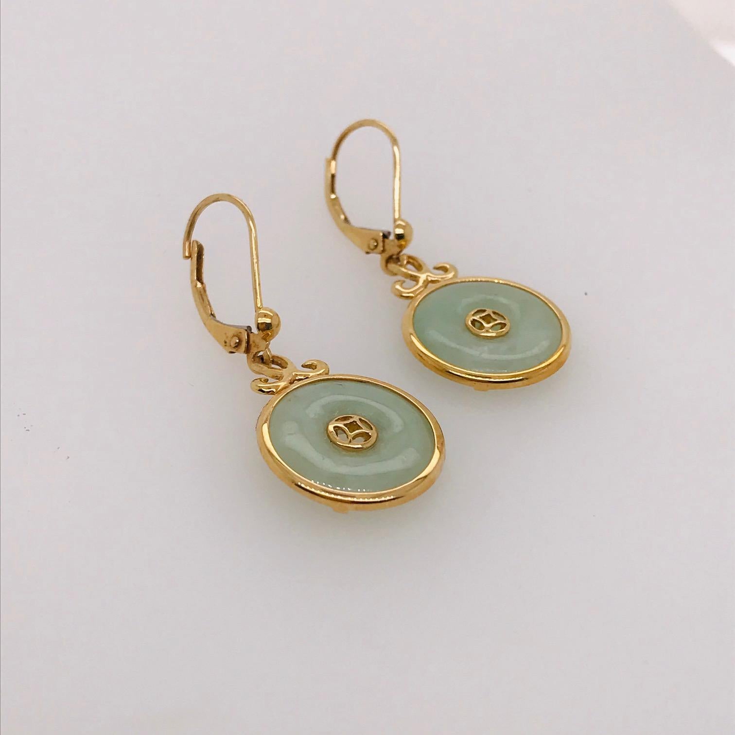 The gorgeous genuine jade earrings are special and unique. With genuine jade pi or disks that are held in 14k yellow gold casings that are attached to complimentary yellow gold earring lever-backs that have unique hand fabricated gold designs on