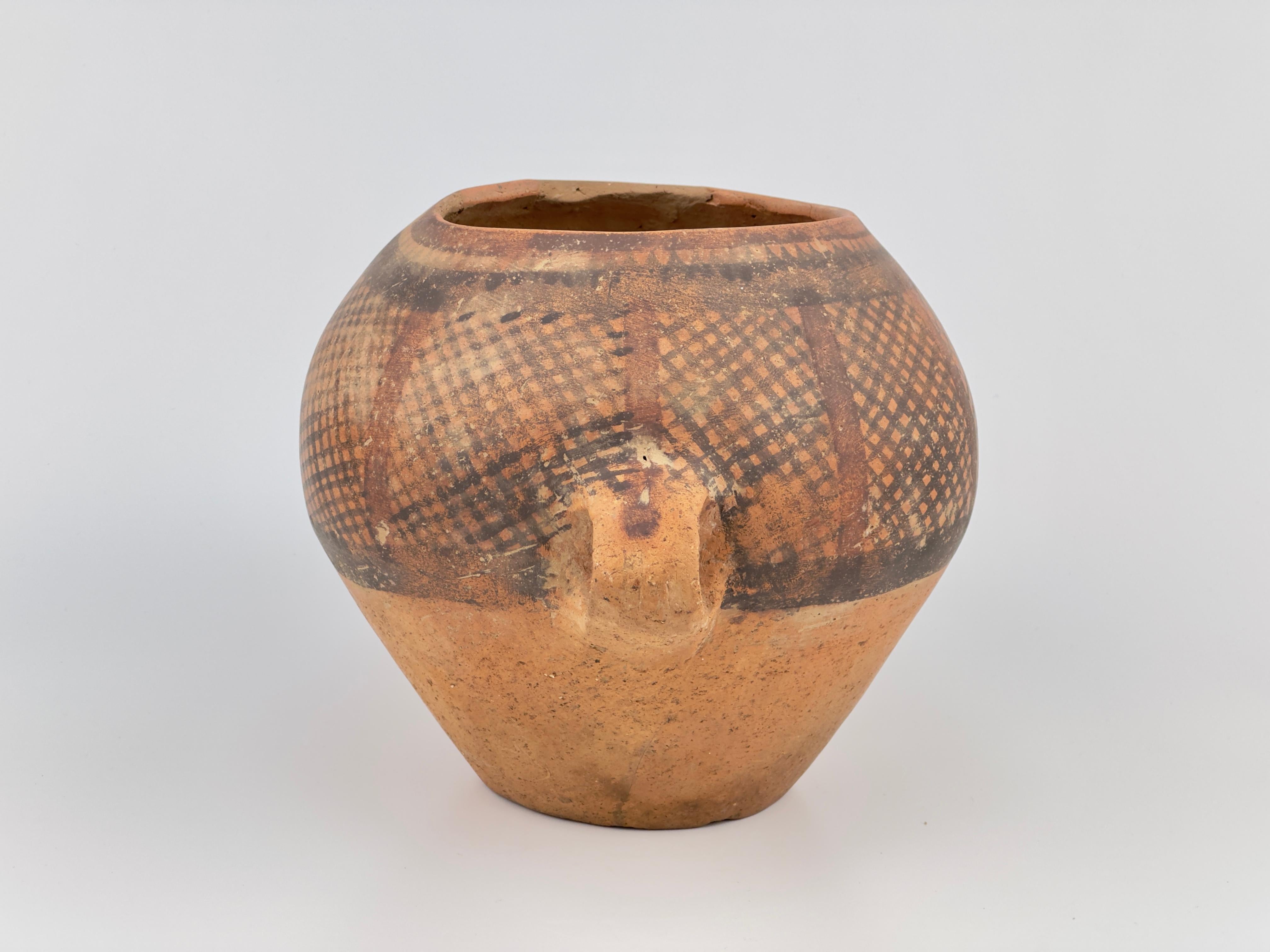 This Neolithic pottery presents a robust form with a rounded bottom, tapering to a wide, open top. It features two small loop handles symmetrically placed on either side. The vessel's surface displays an elaborate pattern created through a technique